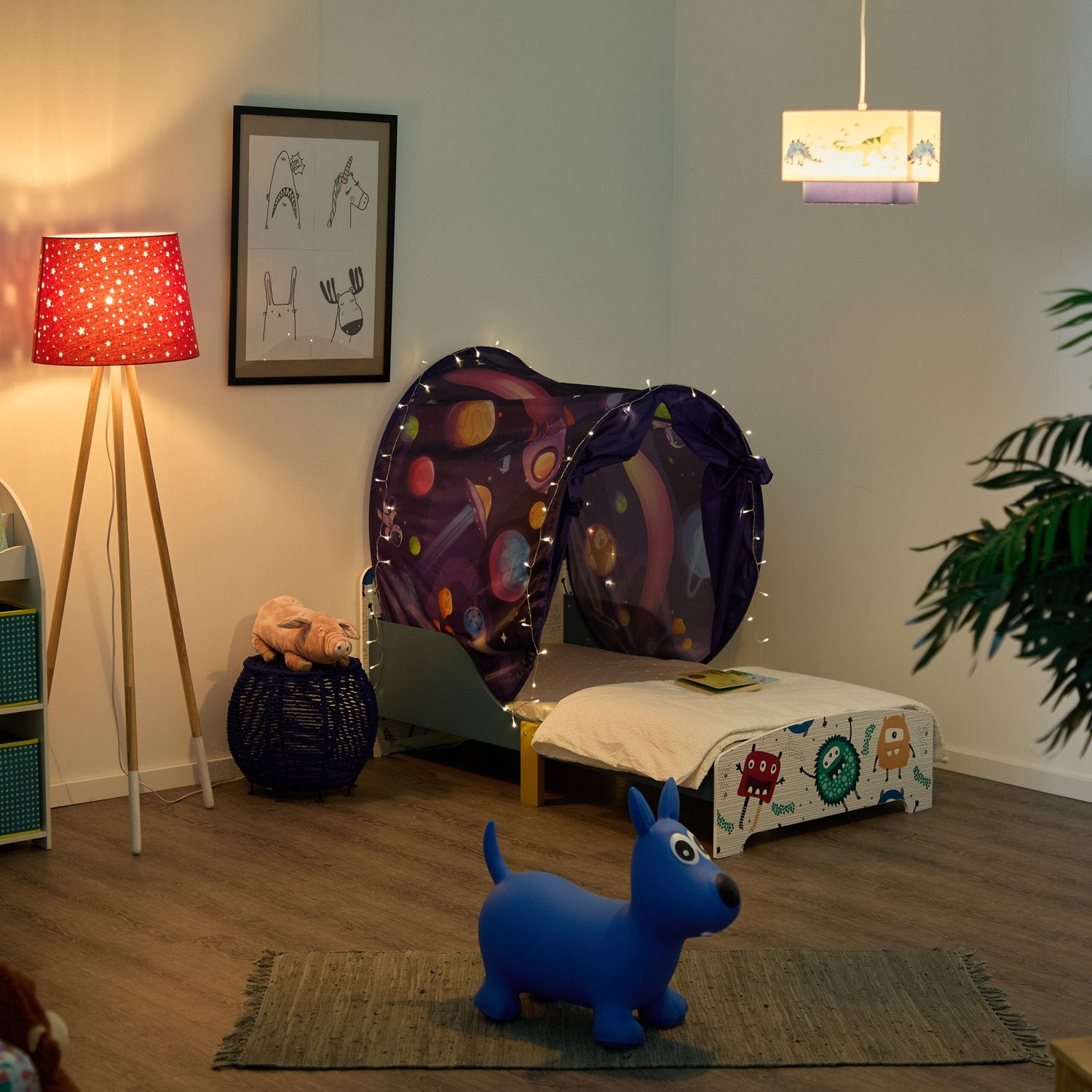 Un juguete de perro azul está sobre una alfombra en una habitación infantil con cama y tienda espacial.
