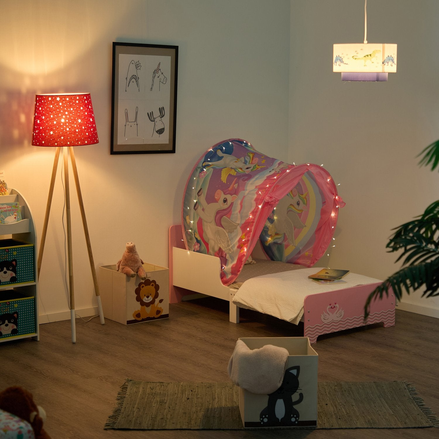 Habitación infantil con cama rosa, tienda y lámpara de estrellas. Se ven juguetes y cajas.