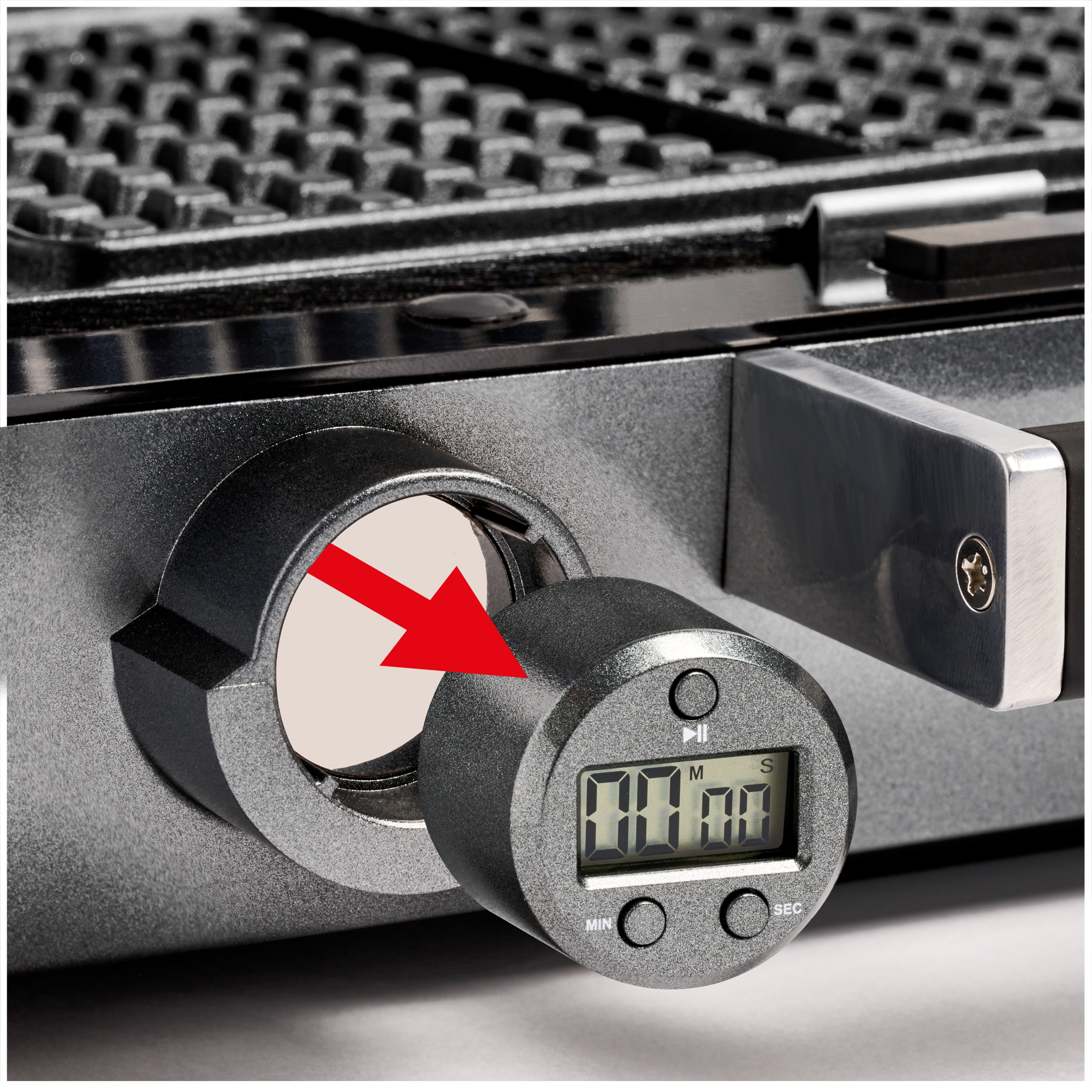 A red arrow points to a digital timer dial on a black waffle maker.