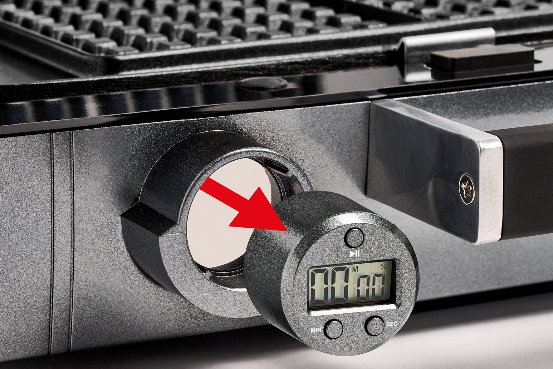 Una freccia rossa indica un timer digitale rimovibile su una piastra per waffle.