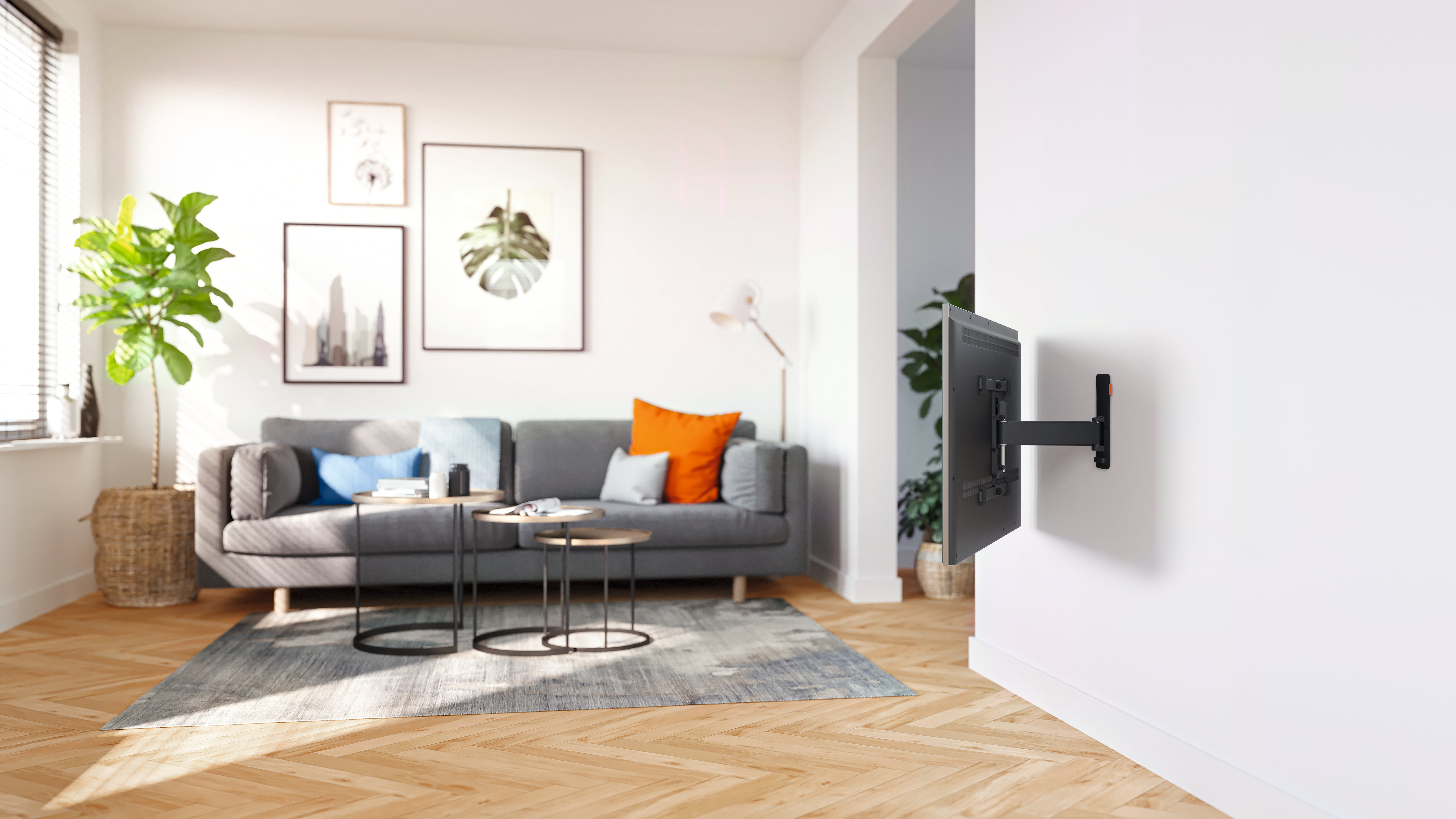 Nowoczesny salon z szarą sofą, stolikami bocznymi i telewizorem na ścianie.