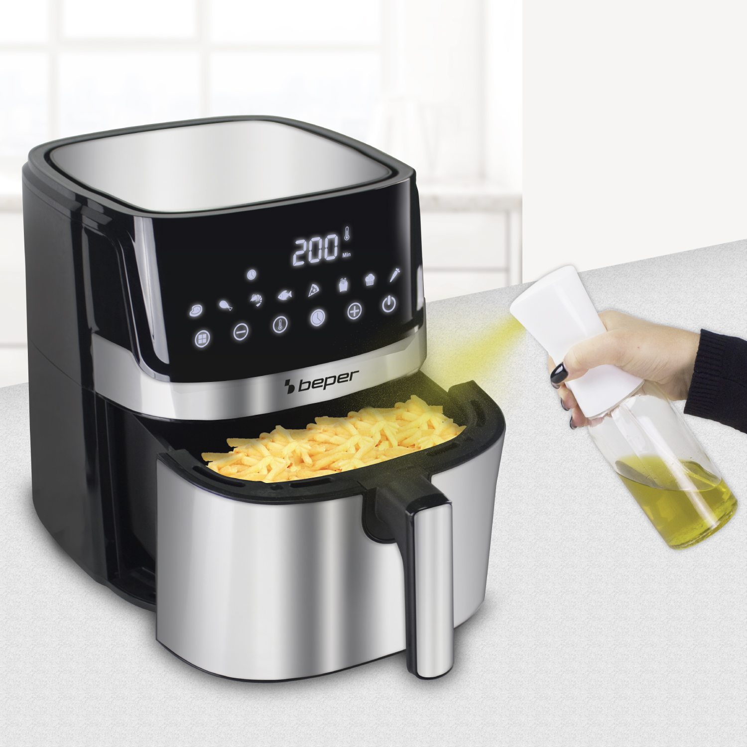 Una mano spruzza olio su patatine fritte in una friggitrice ad aria nera con display digitale.