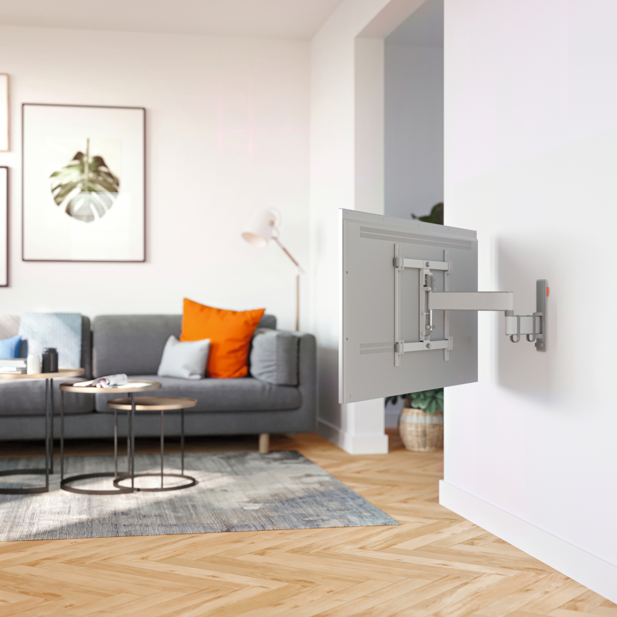 Nowoczesny salon z szarą sofą, stolikami bocznymi i telewizorem na ścianie.