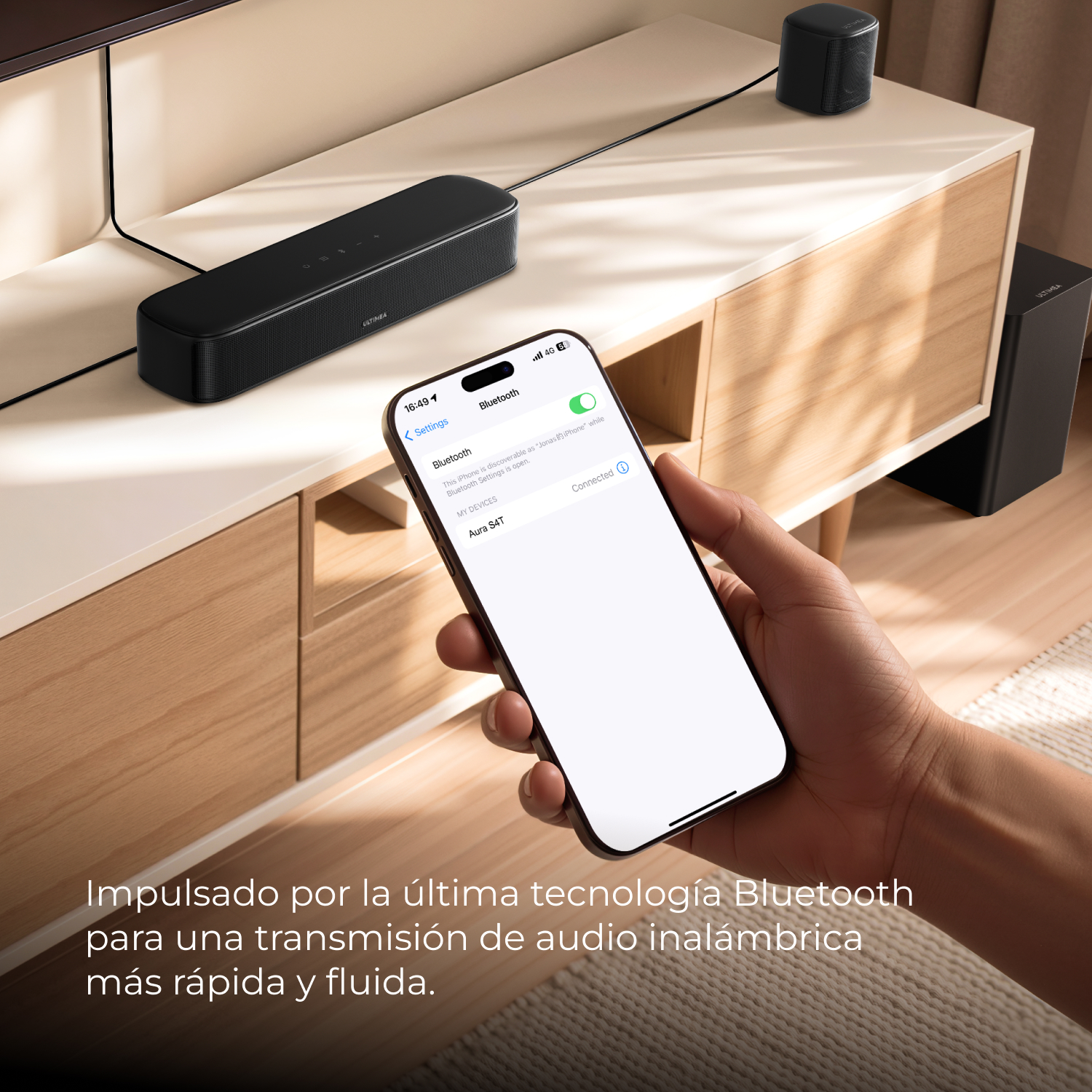 Un smartphone se conecta por Bluetooth a una barra de sonido y altavoz negros.