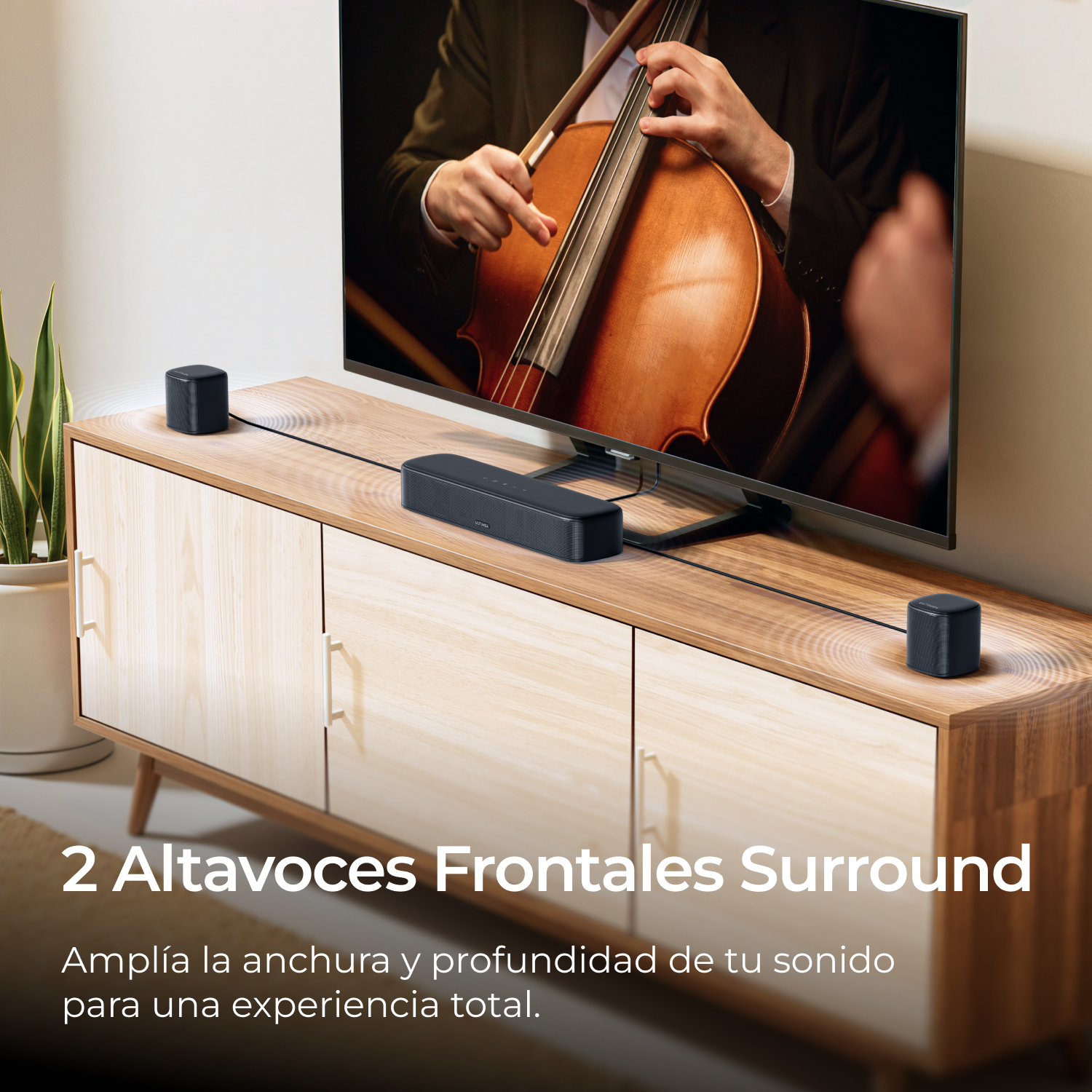 Un hombre toca el violonchelo frente a un televisor con dos altavoces.