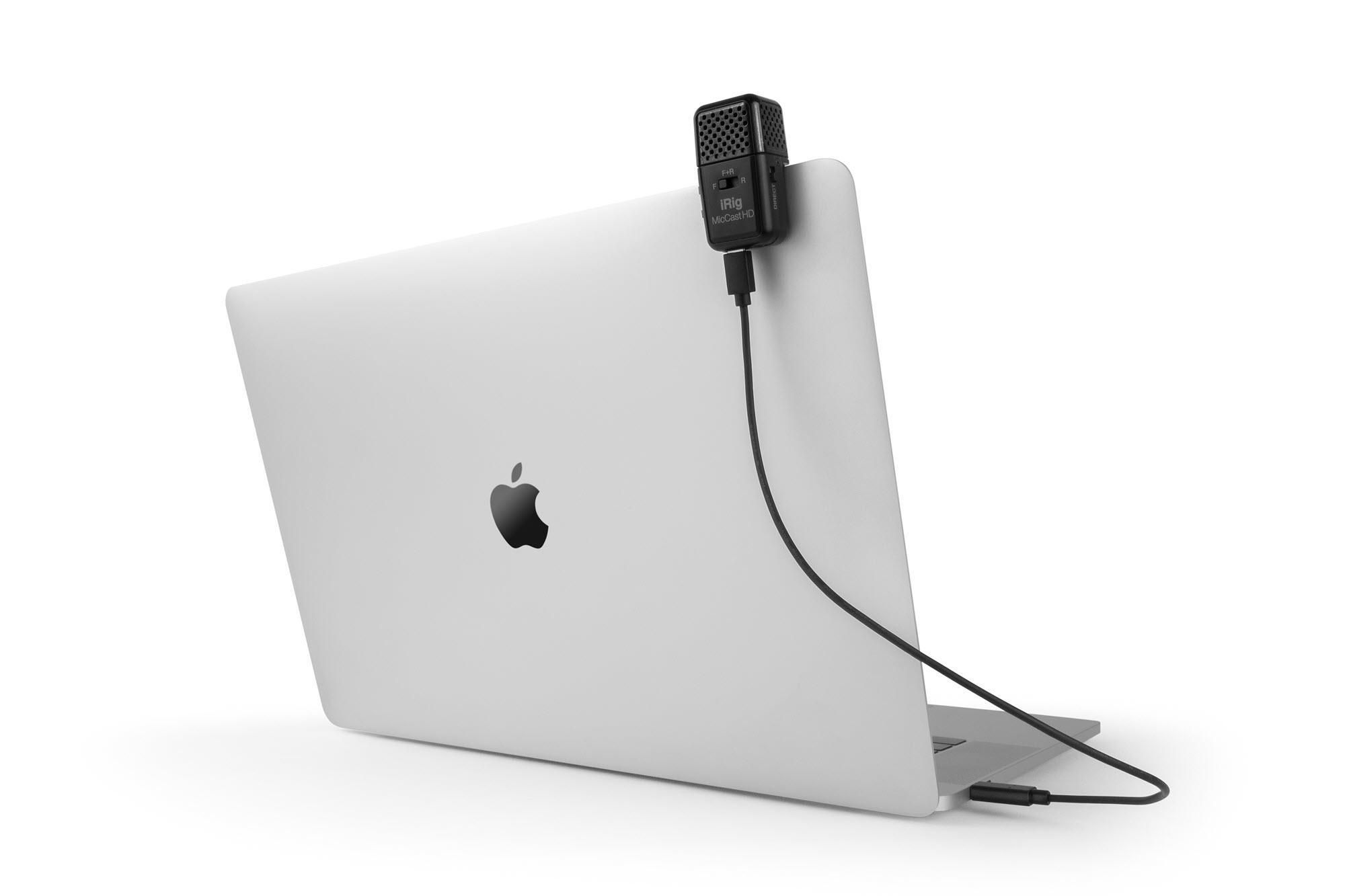 Ein schwarzes Mikrofon mit Kabel ist an einem weißen Laptop befestigt.
