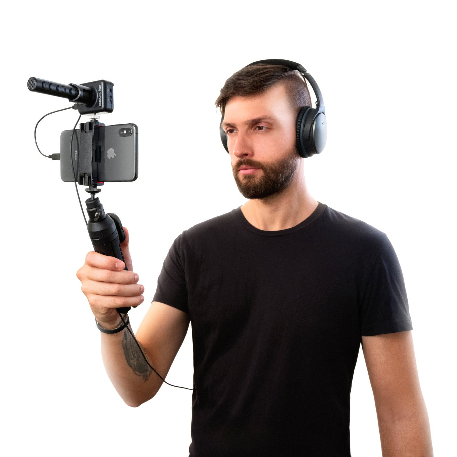 Uomo con cuffie tiene smartphone con microfono e gimbal.