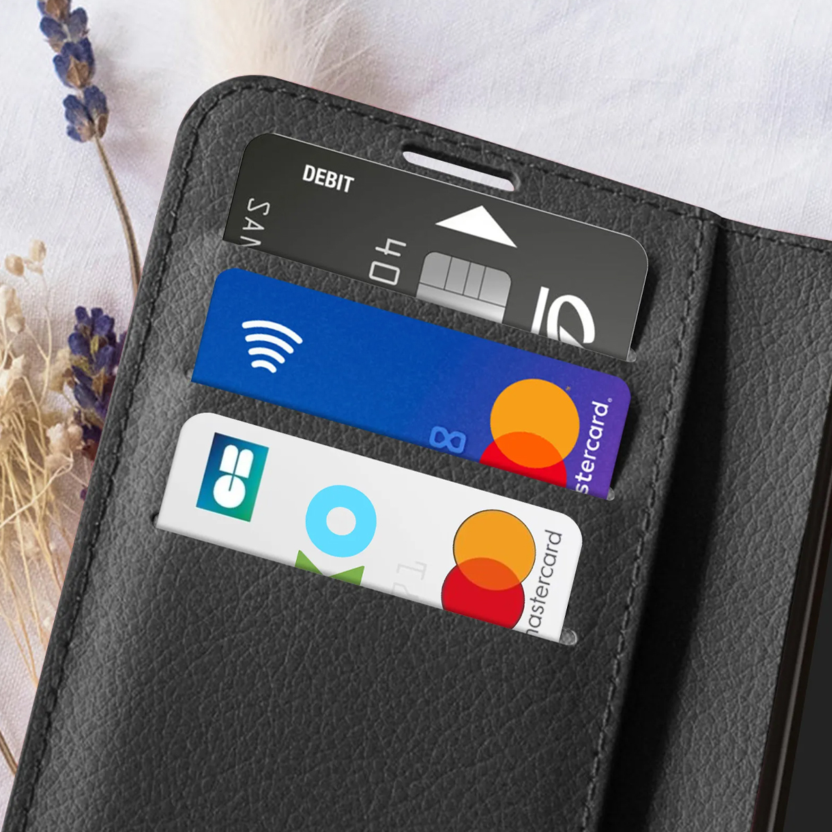 Portefeuille noir avec trois fentes pour cartes : Débit, bleu avec symbole WiFi, blanc avec logos.