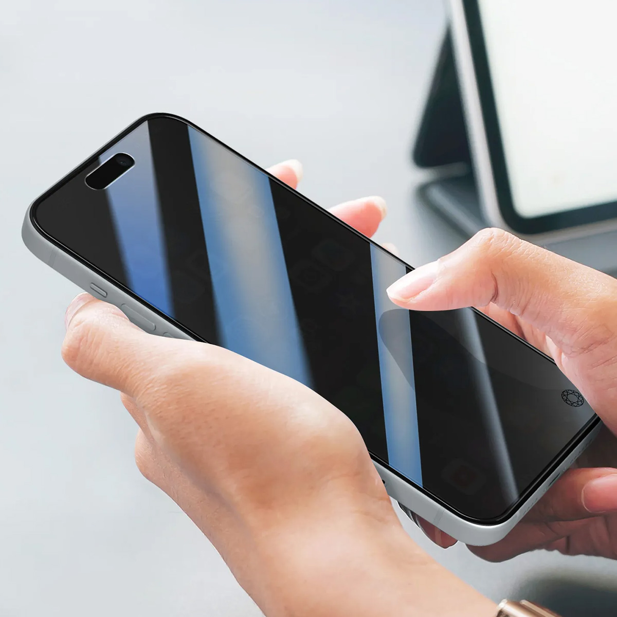 Une personne tient un smartphone à écran noir et cadre argenté.