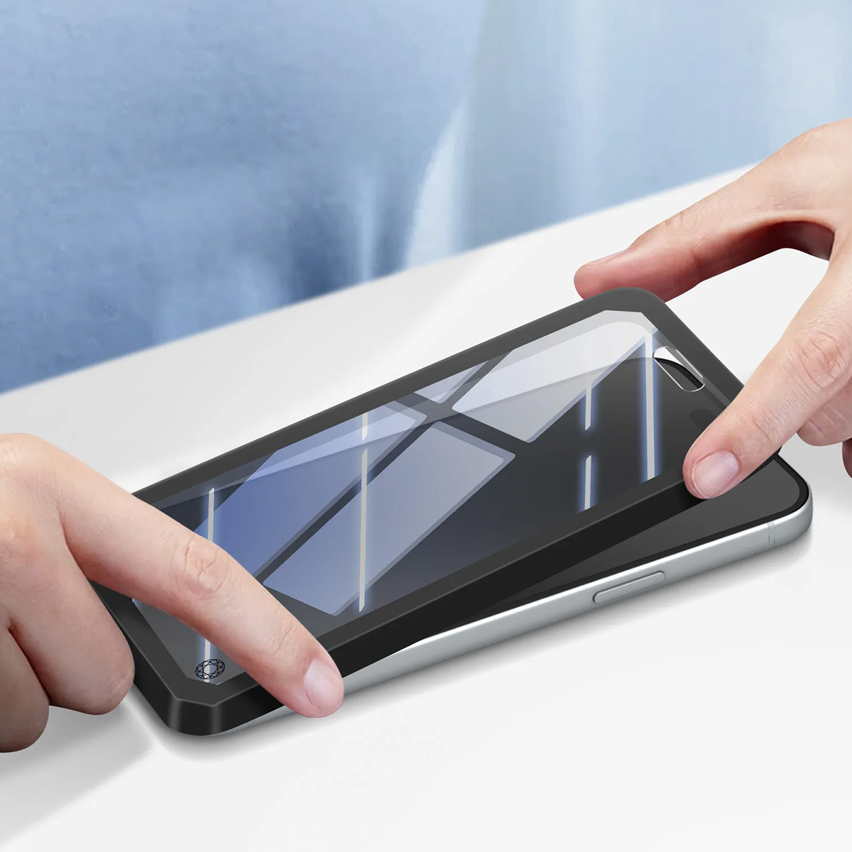 Mains appliquant un protecteur d'écran sur un smartphone.