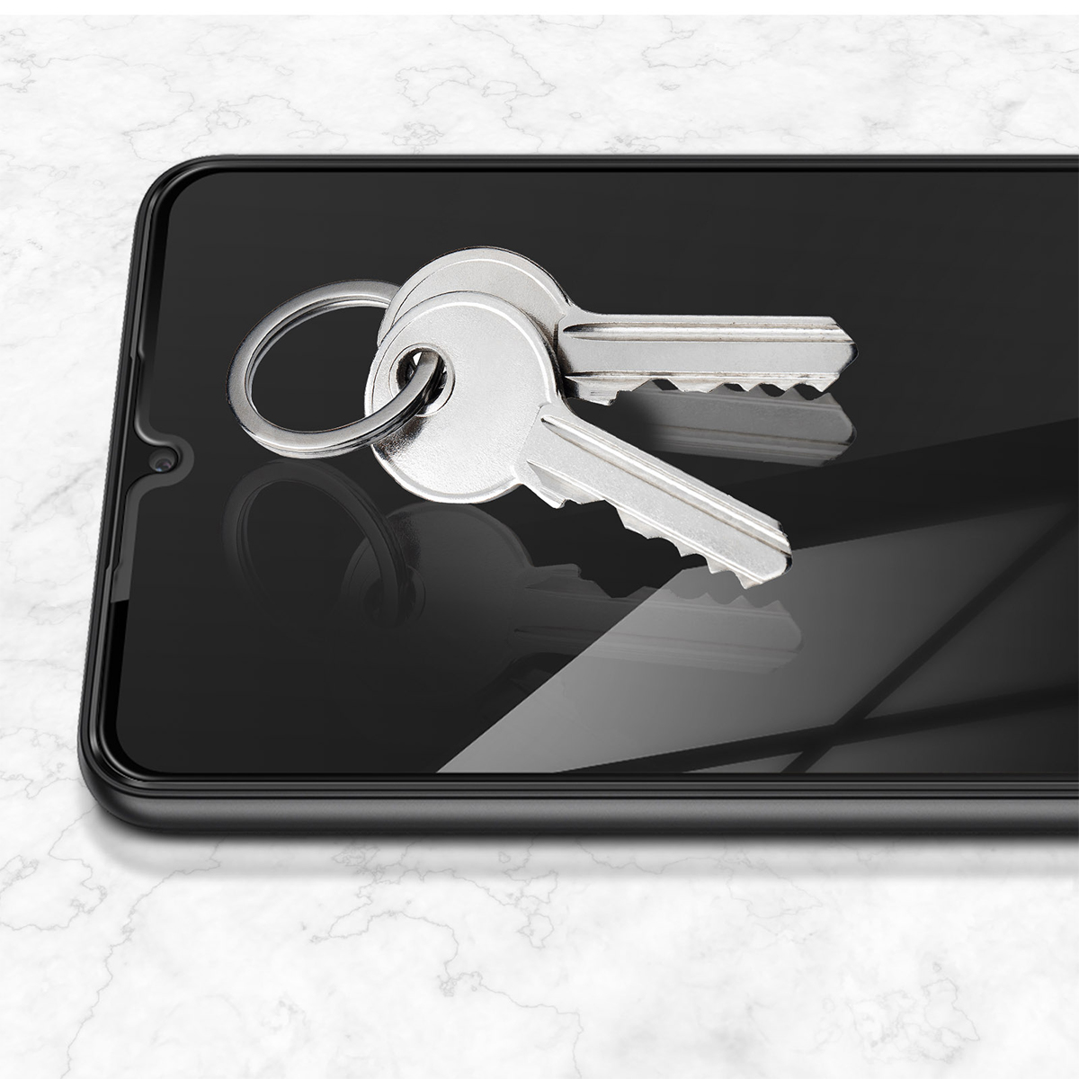 Due chiavi argentate appoggiate su uno schermo di smartphone scuro.