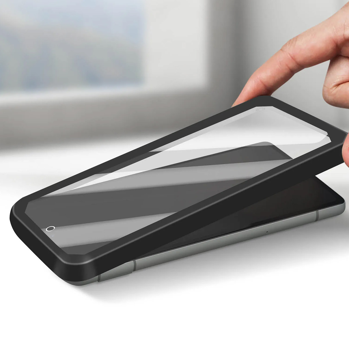 Une main place une coque de protection noire sur un smartphone.