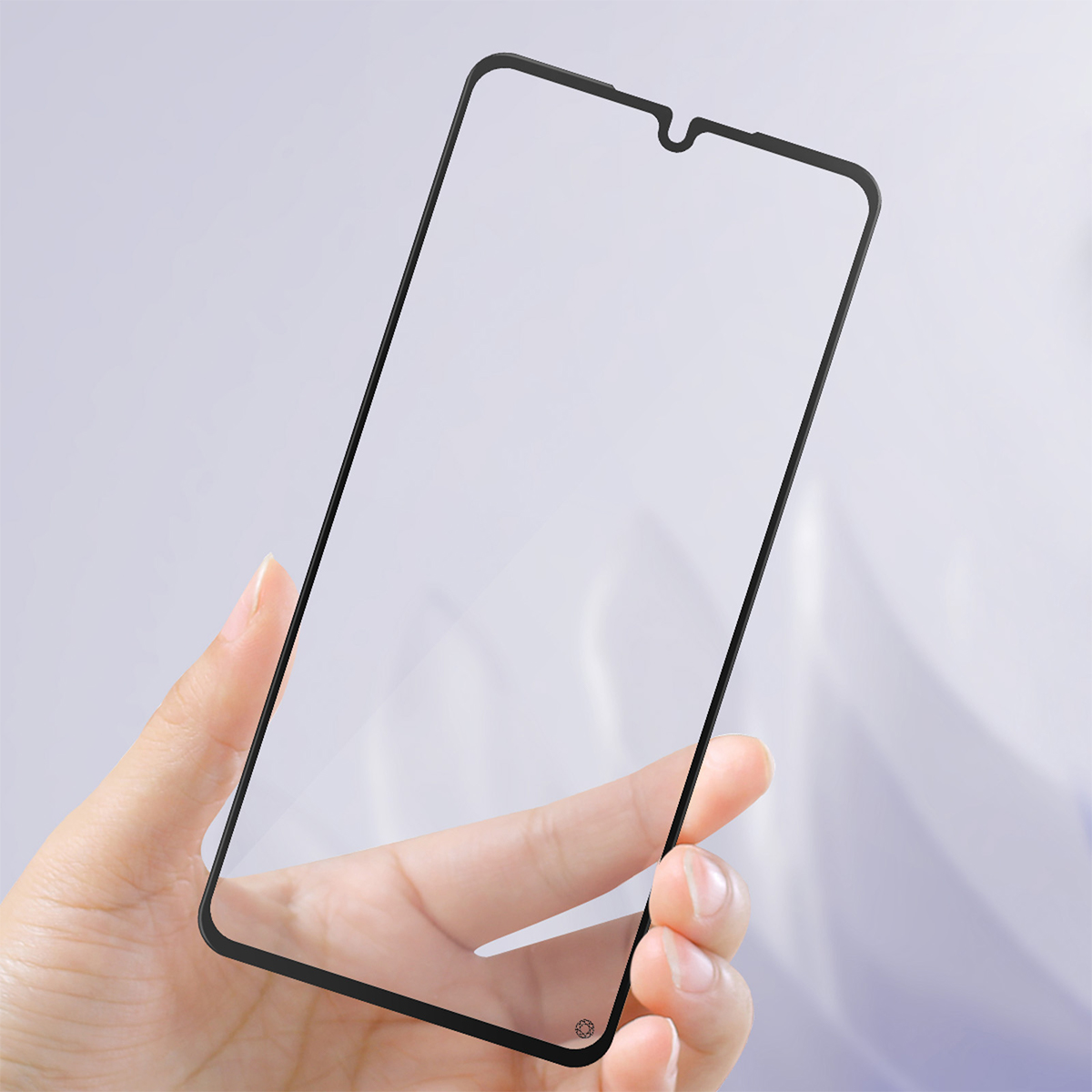 Una mano tiene una protezione per schermo del telefono nera su sfondo grigio chiaro.