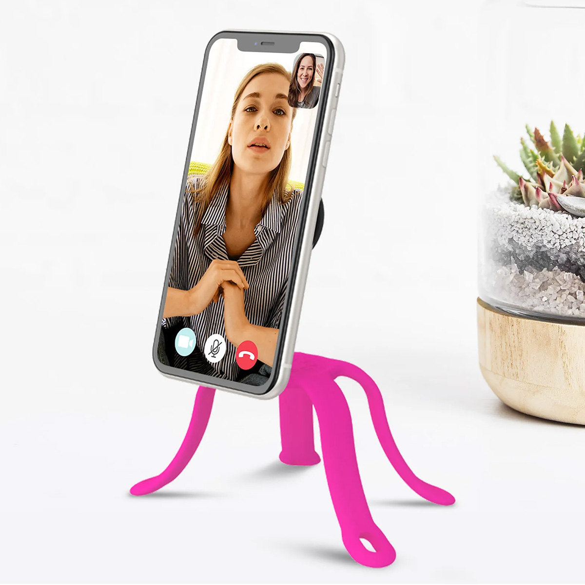 Uno smartphone su un supporto rosa mostra una videochiamata con due donne.