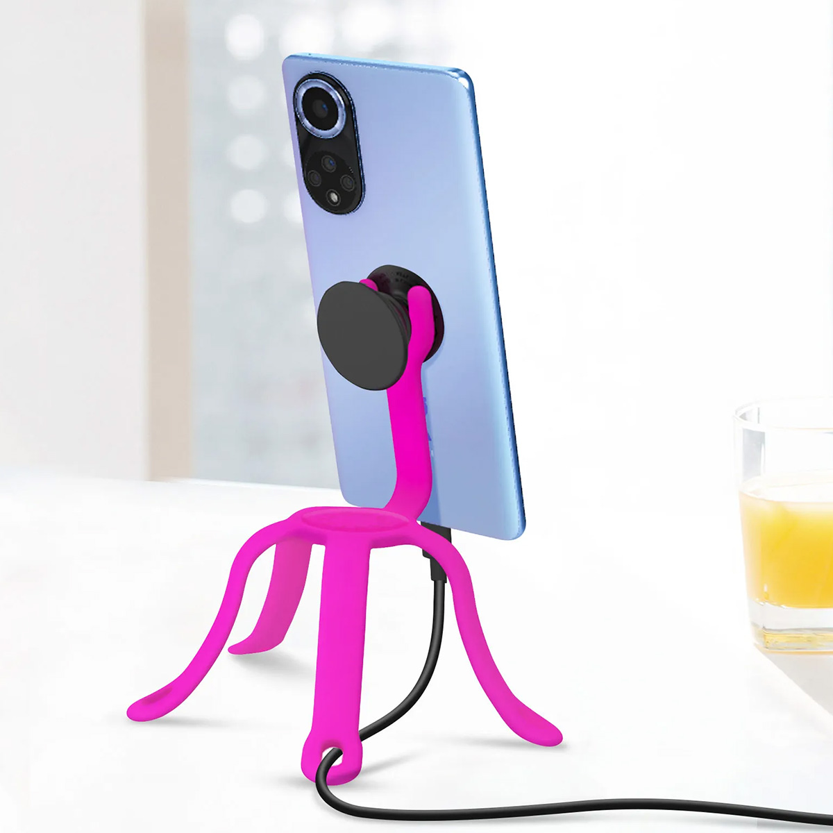 Uno smartphone blu su un treppiede flessibile rosa con un PopSocket.