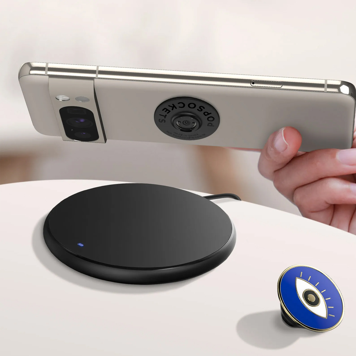 Un teléfono con PopSocket se carga en una base de carga negra.