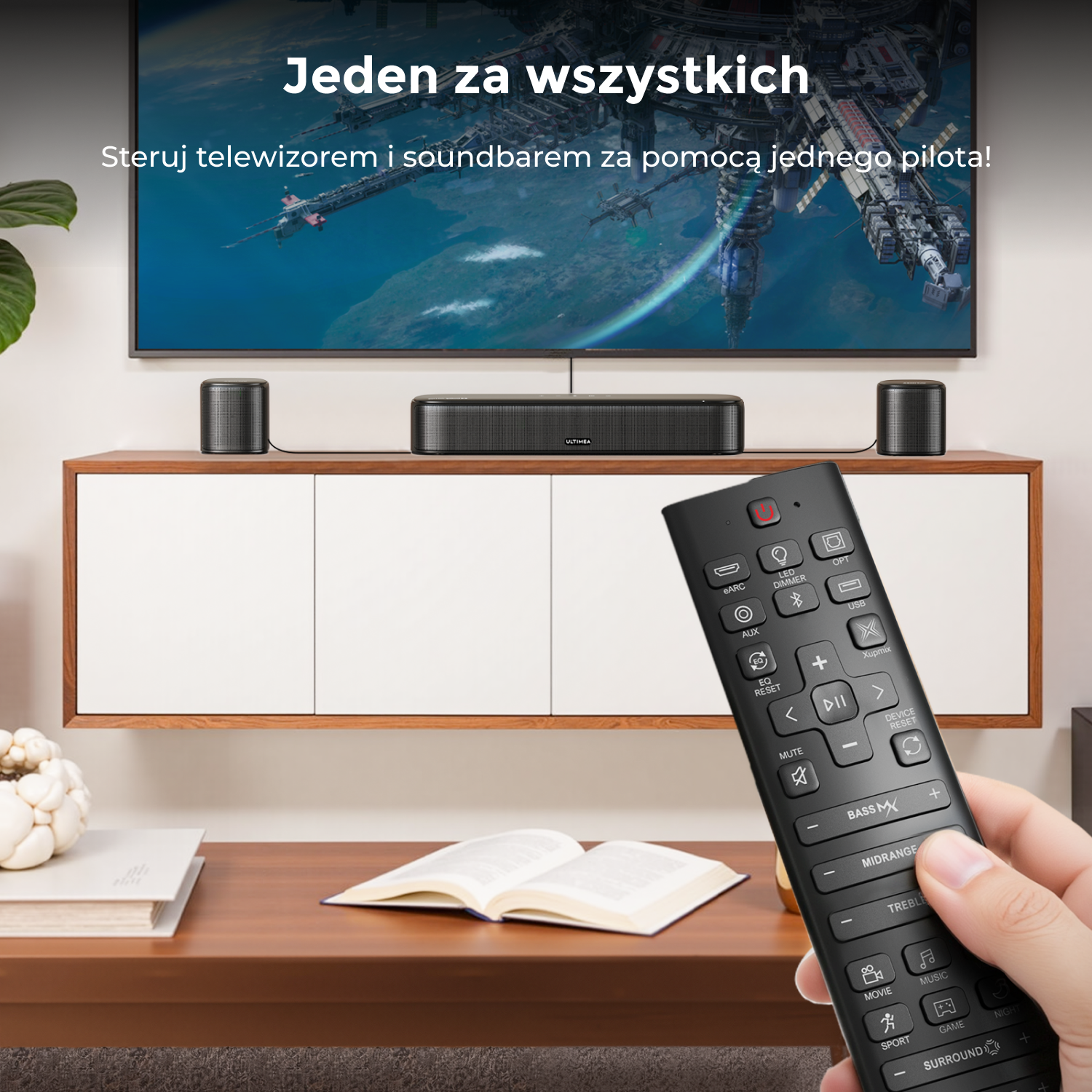 Ręka trzyma pilota przed telewizorem, soundbarem i głośnikami.