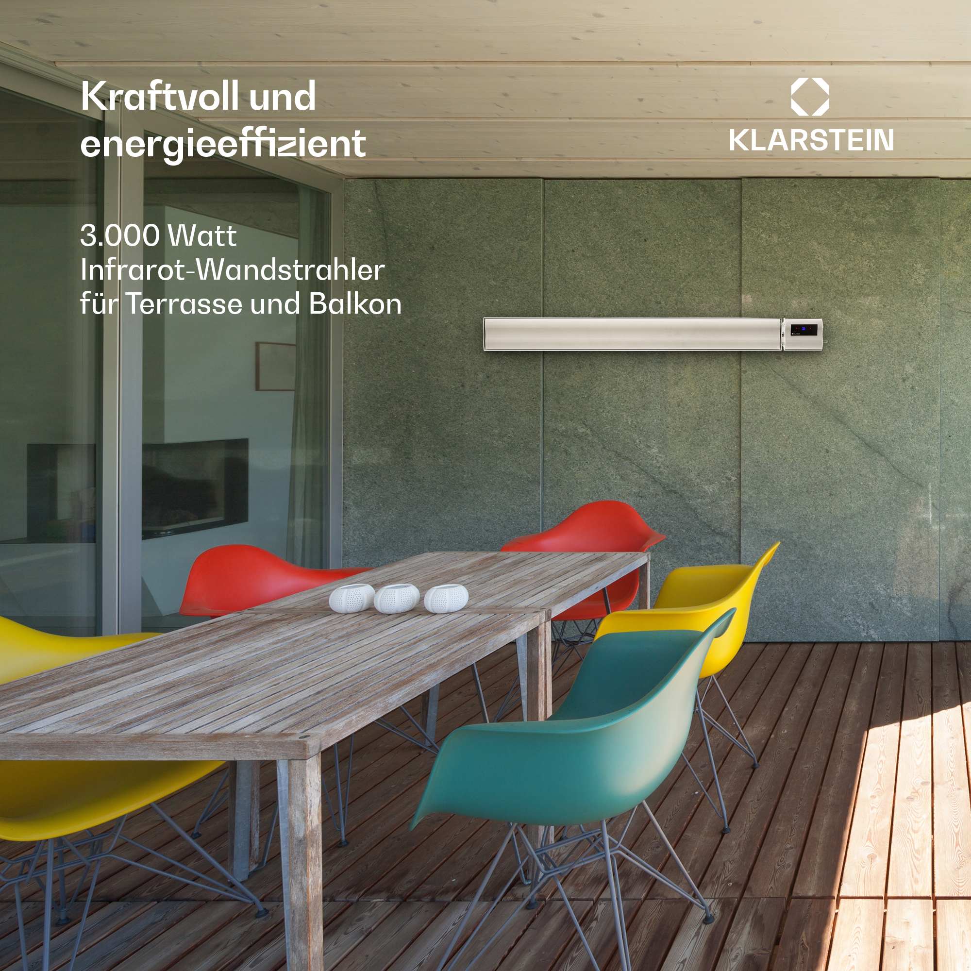 Ein Heizstrahler hängt an der Wand über einem Holztisch mit bunten Stühlen.