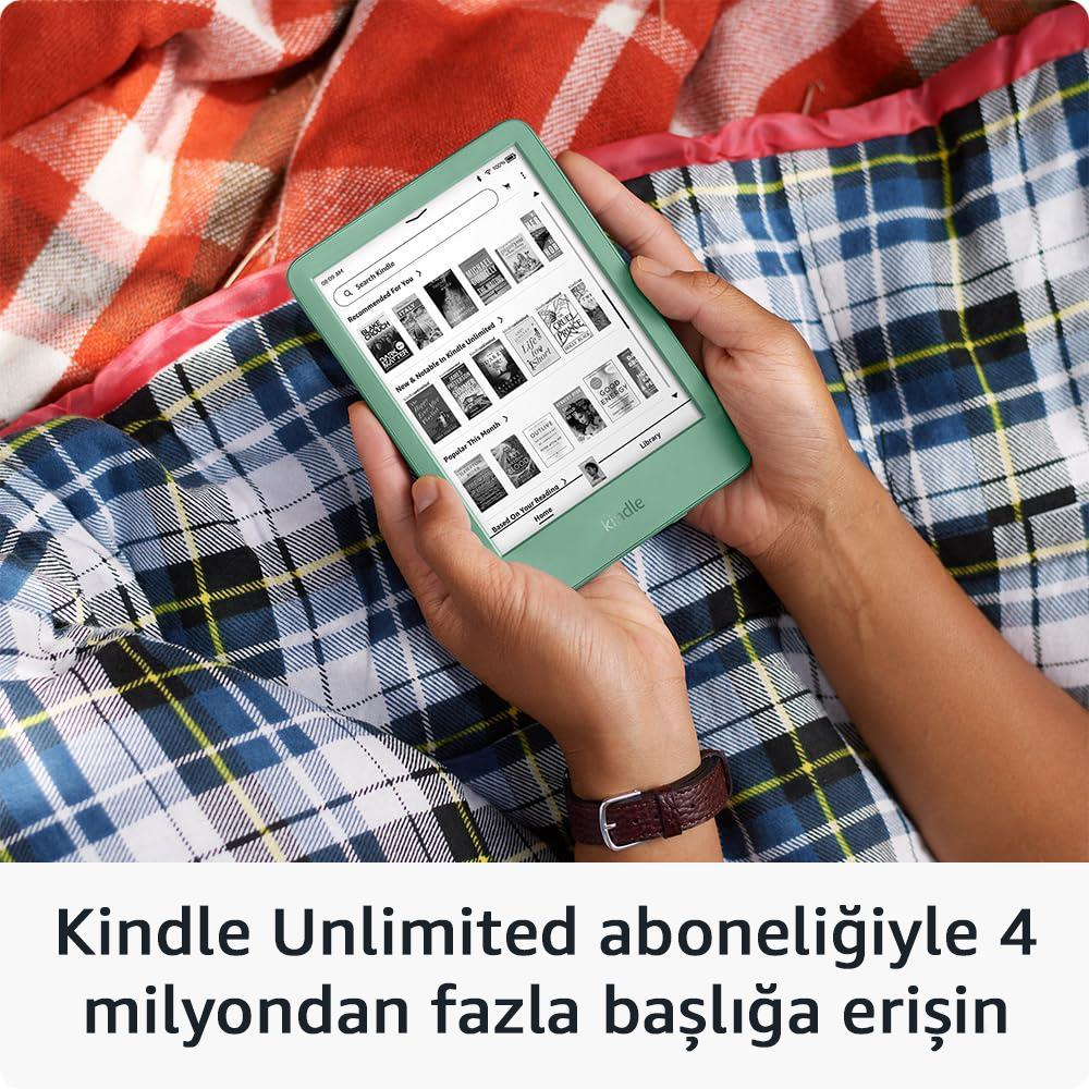 Una persona tiene un Kindle verde appoggiato su una coperta a quadri. Focus sul dispositivo.