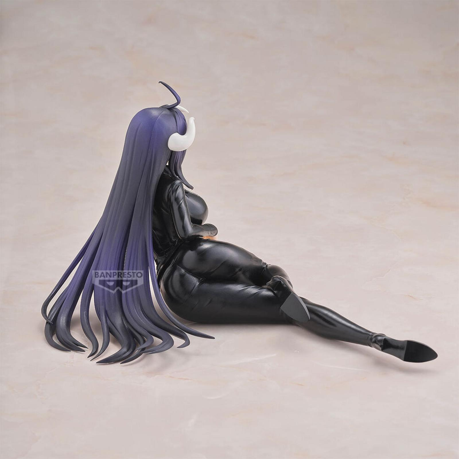 Una figura con pelo morado y cuernos blancos se sienta vestida de negro.