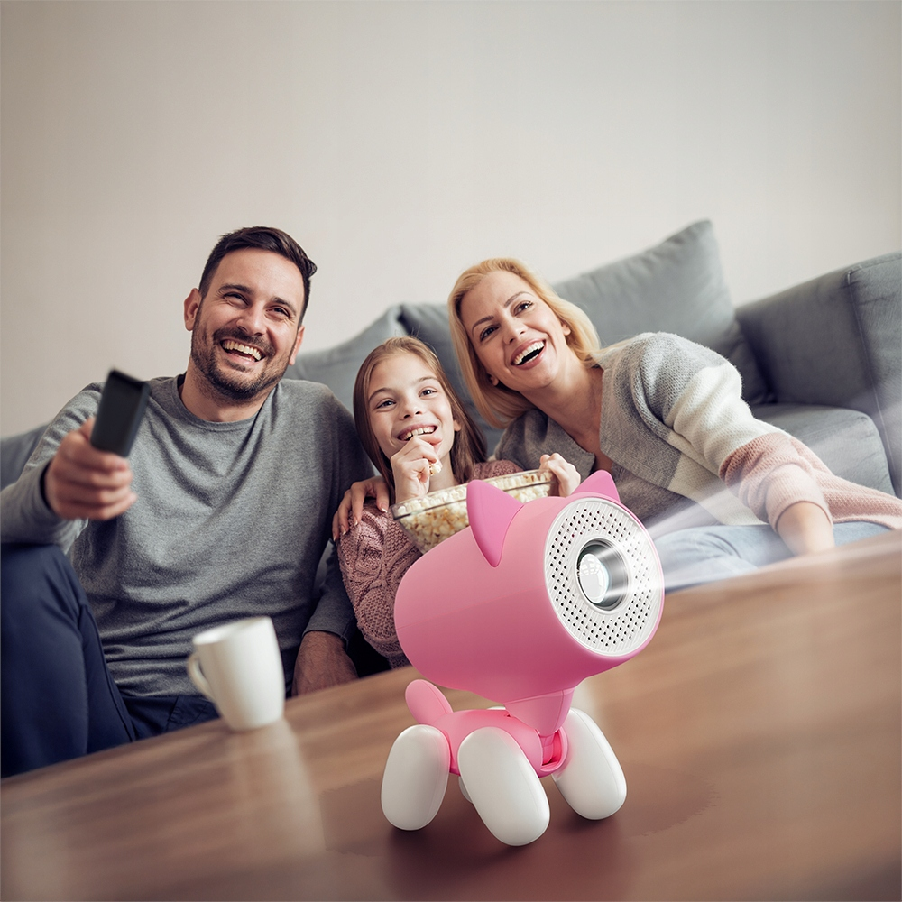 Familia viendo película con proyector rosa y palomitas en el sofá.