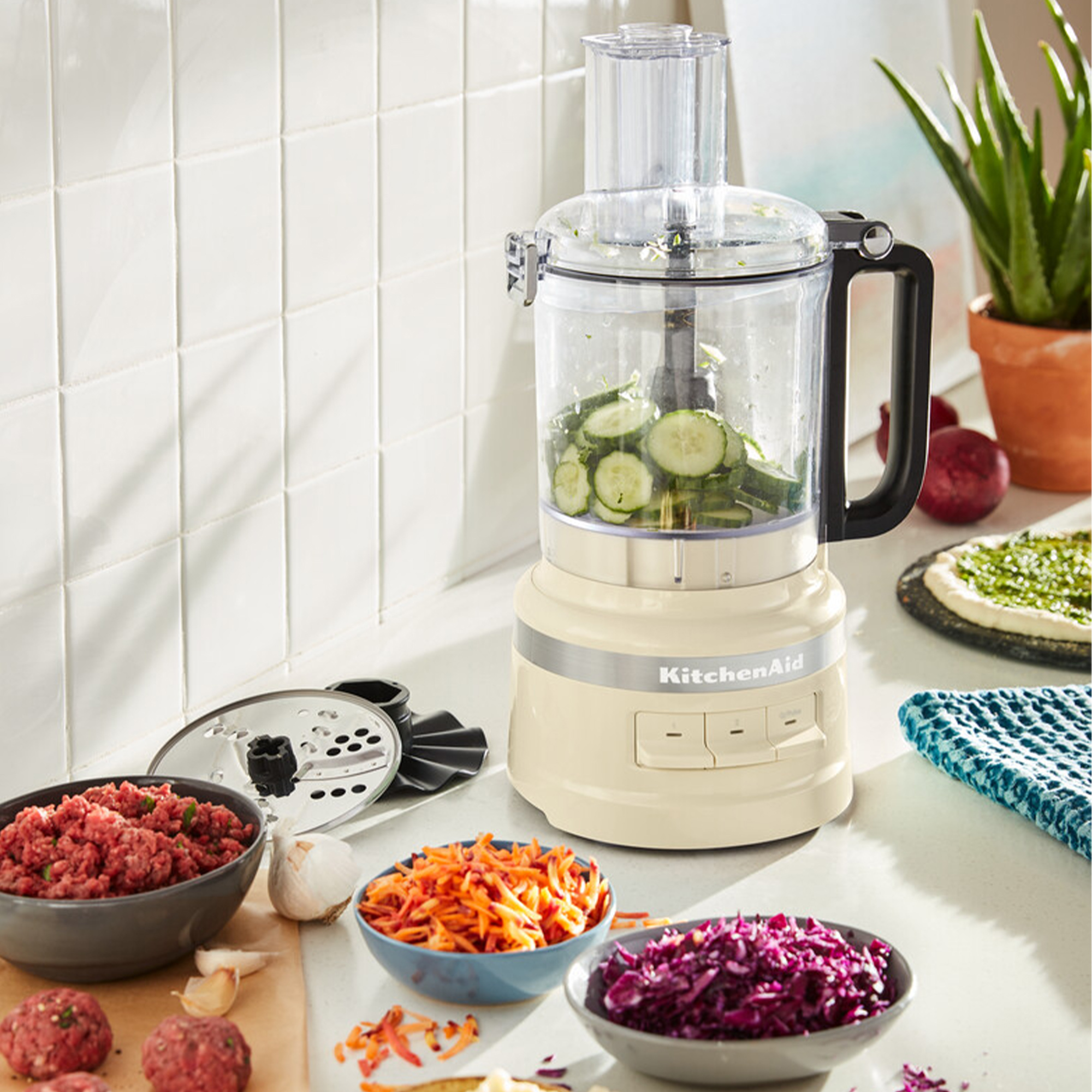 Küchenmaschine mit Gurkenscheiben, Hackfleisch, Karotten und Rotkohl.