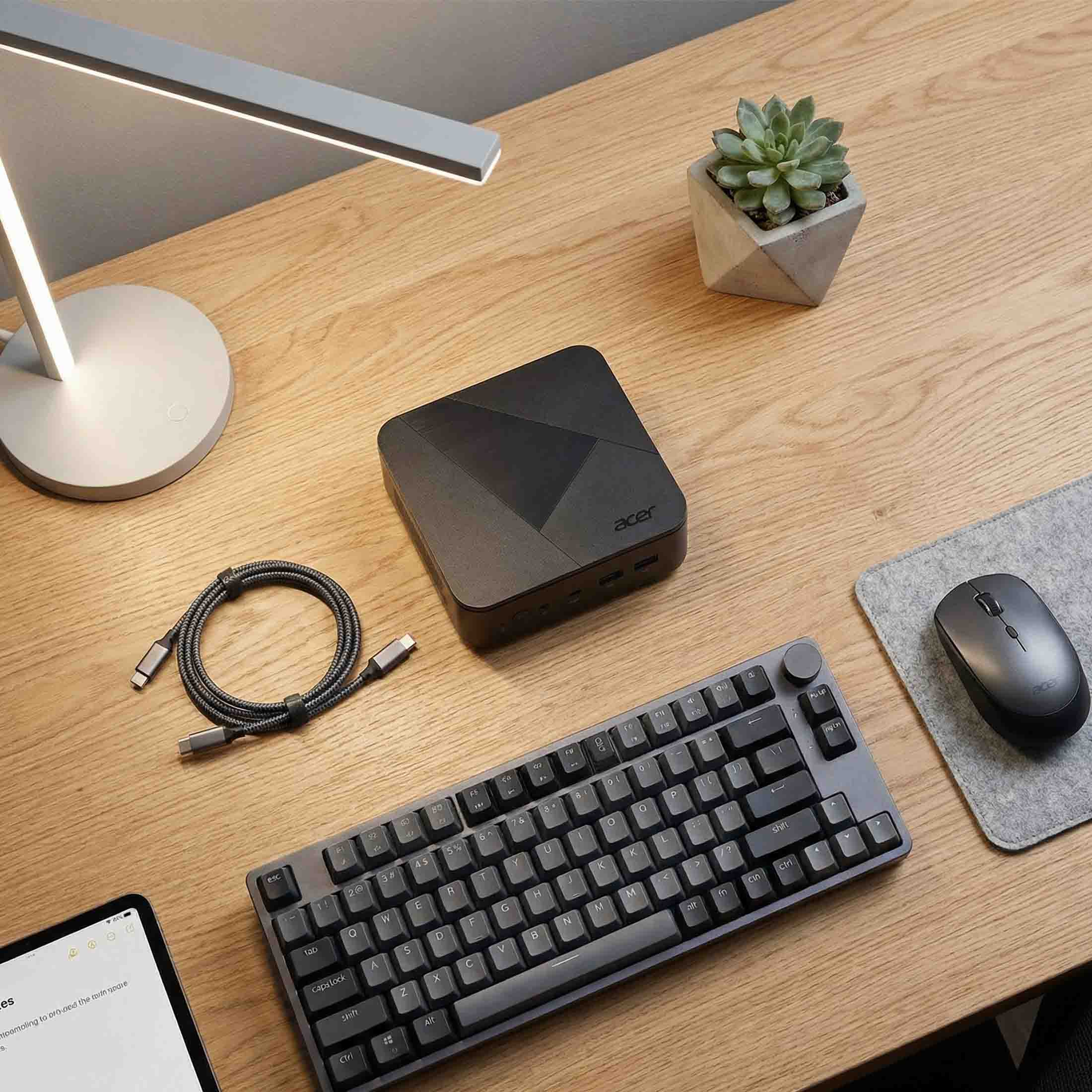 Ein Schreibtisch mit Tastatur, Maus, Minicomputer und Lampe.