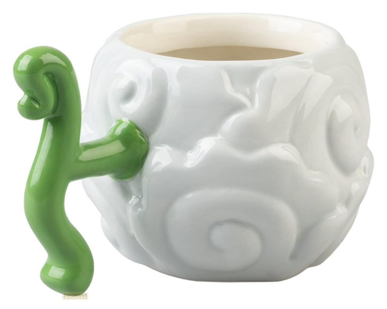 Una taza blanca con una figura verde que trepa como asa.