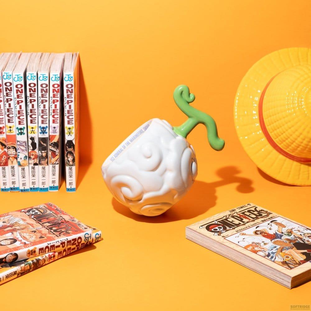 Atrezo de Fruta del Diablo blanca, manga, sombrero amarillo sobre fondo naranja.