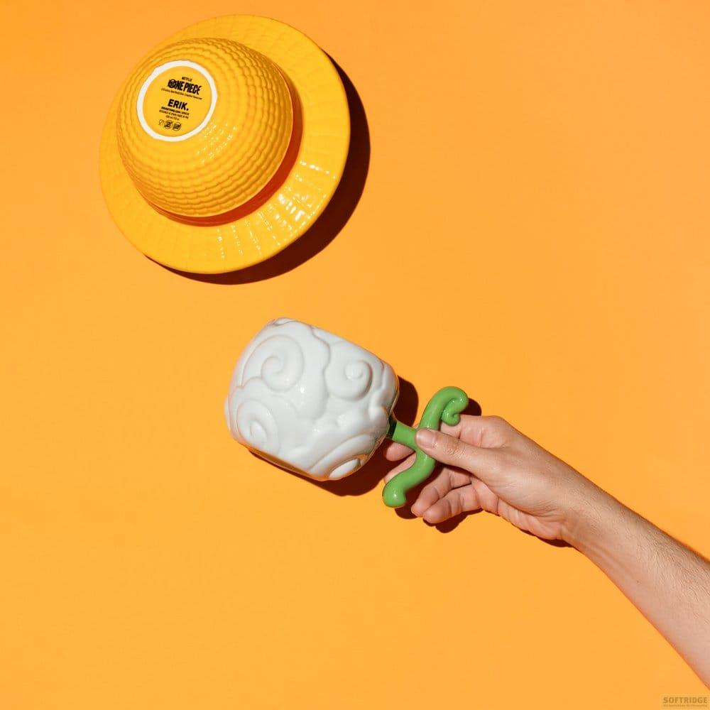 Un sombrero amarillo y una taza de fruta del diablo blanca se muestran sobre fondo naranja.