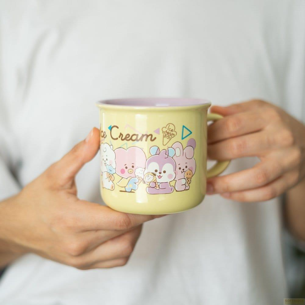 Eine gelbe Tasse mit süßen Cartoon-Tieren und der Aufschrift "Ice Cream".