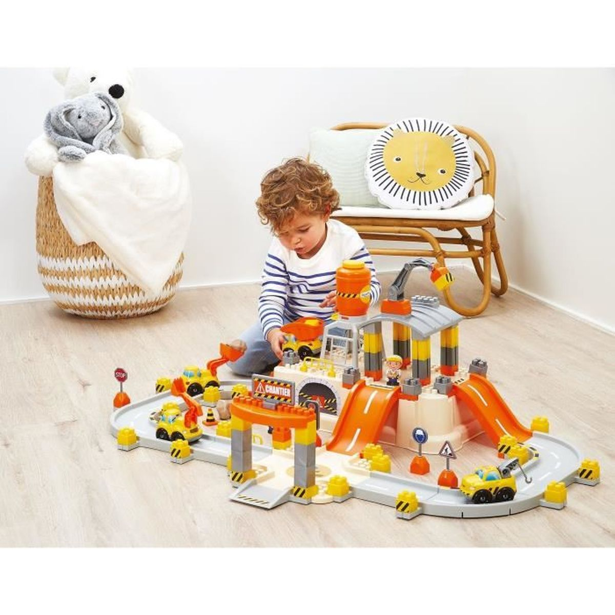 Ein Junge spielt mit einem Baustellen-Spielset mit LKWs und Kran.