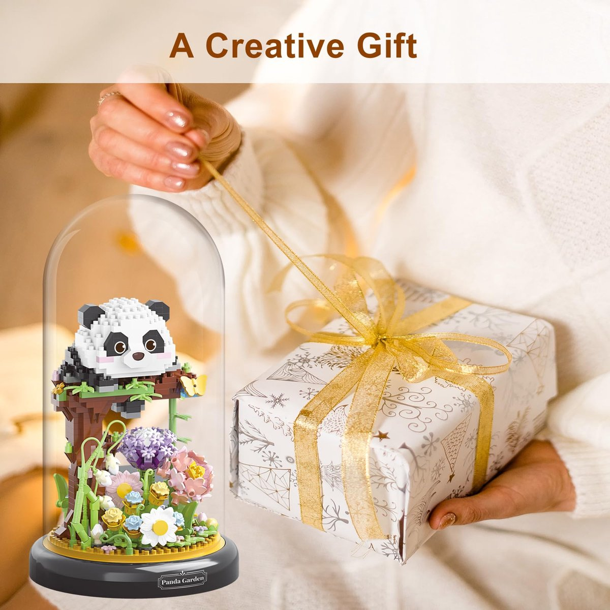 Ein niedlicher Panda-Bausatz unter einer Glasglocke neben einem Geschenk.