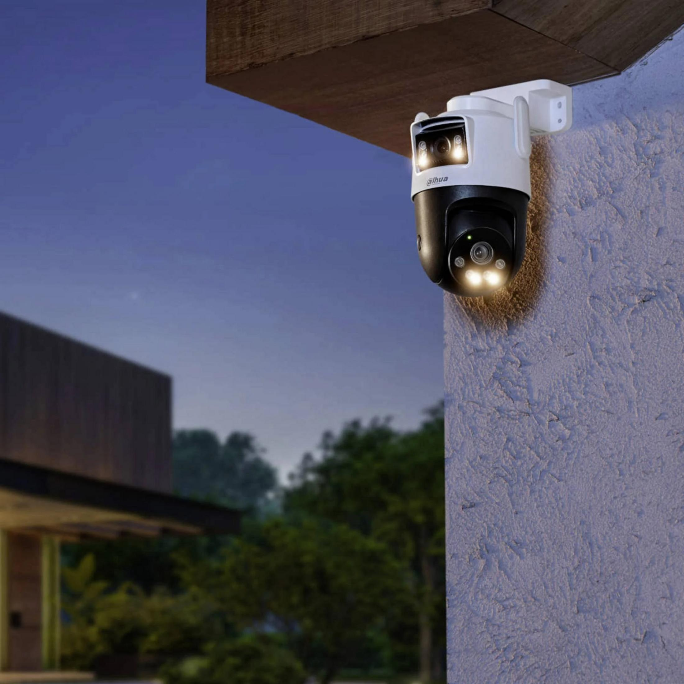 Biała i czarna kamera bezpieczeństwa ze światłami zamontowana na ścianie domu.