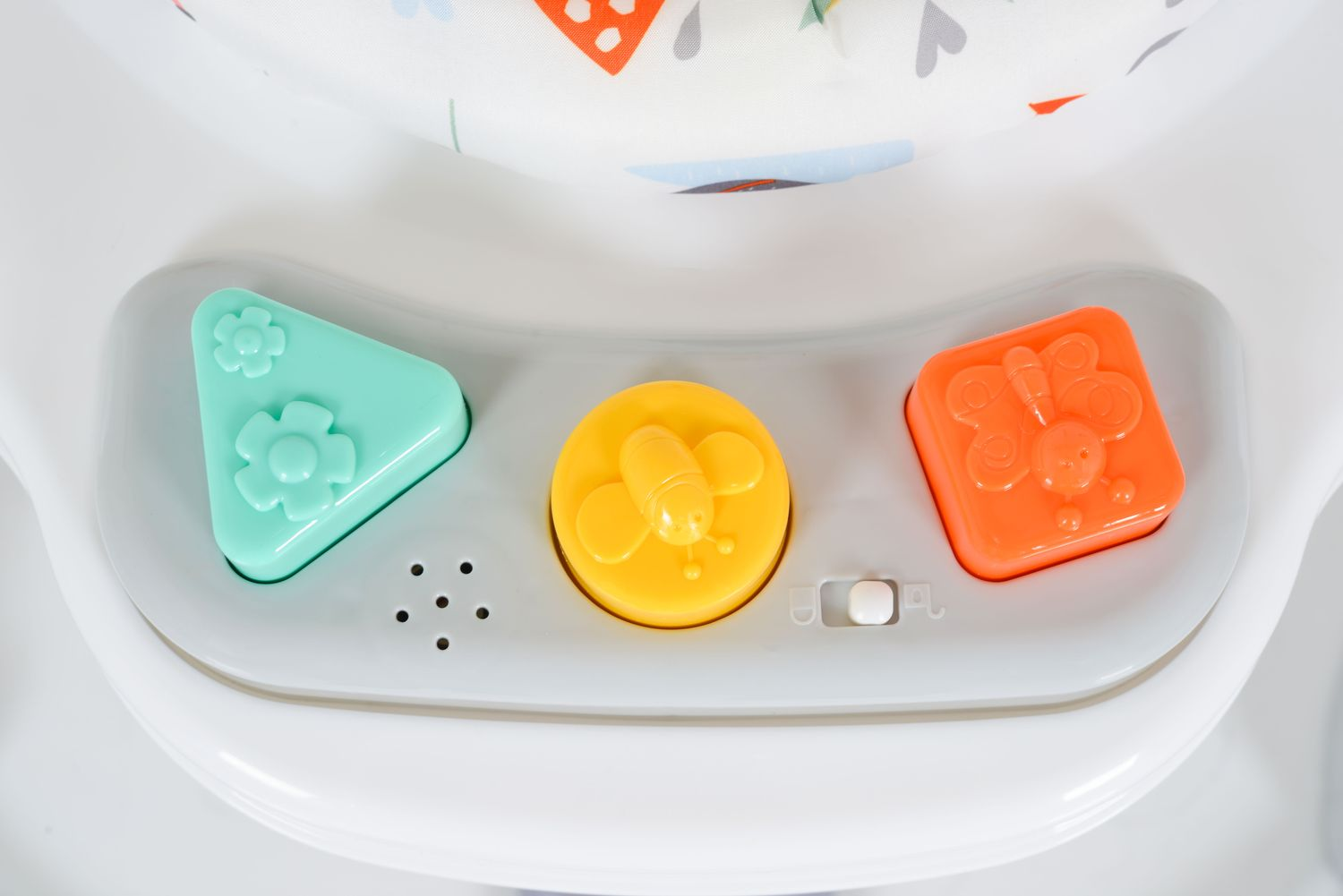 Grüner Dreieck-Knopf mit Blumen, gelber Bienenknopf, orangener Schmetterlingsknopf auf einem Spielzeug.