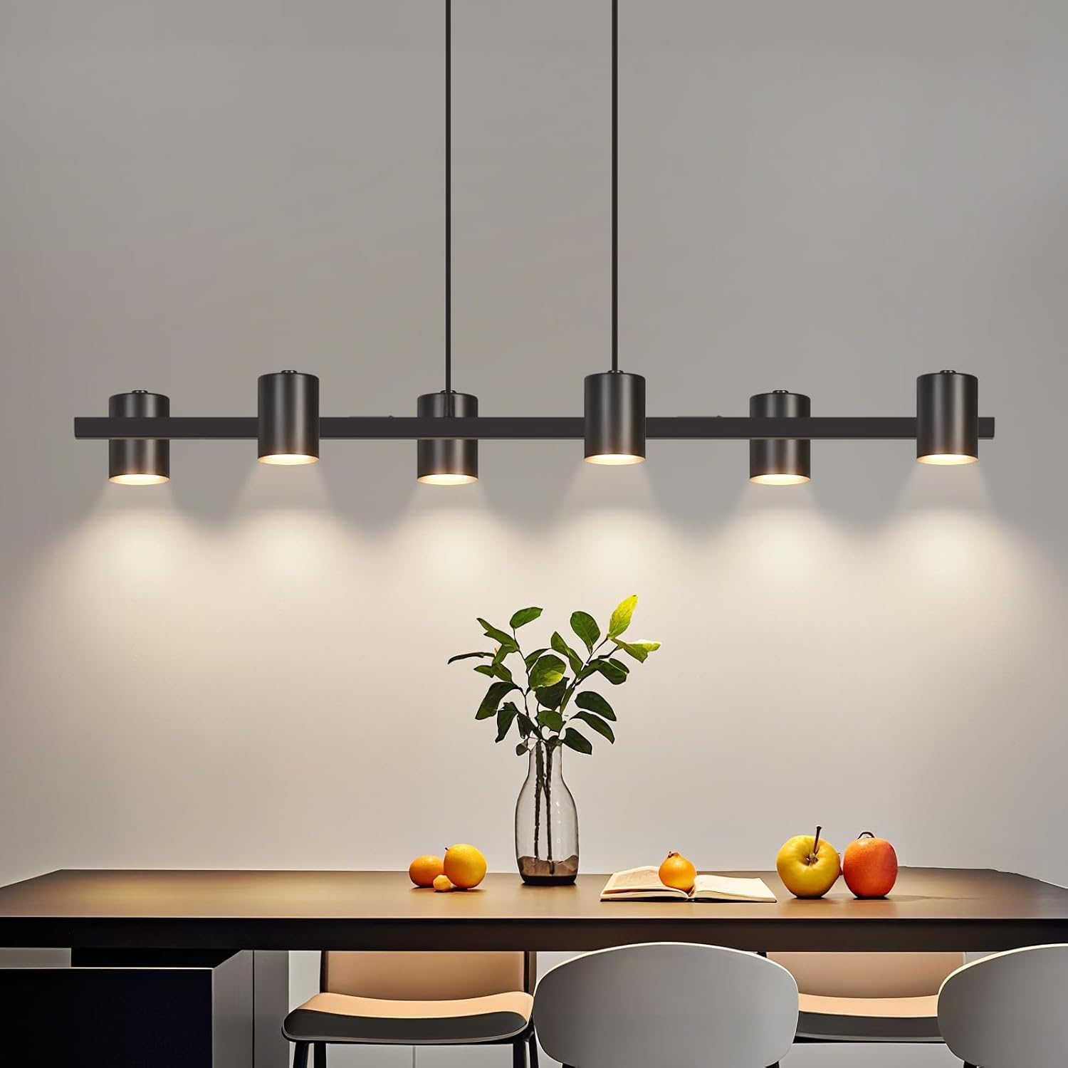 Moderna lampada a sospensione nera sopra tavolo in legno con frutta e vaso.