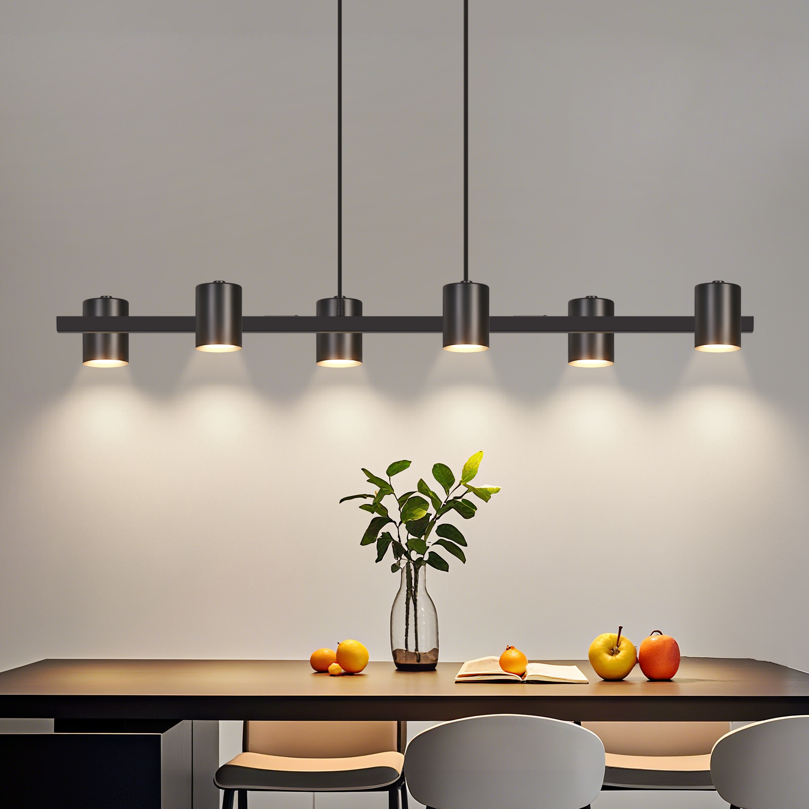 Eine lineare Hängeleuchte über einem Tisch mit Früchten und einer Vase.