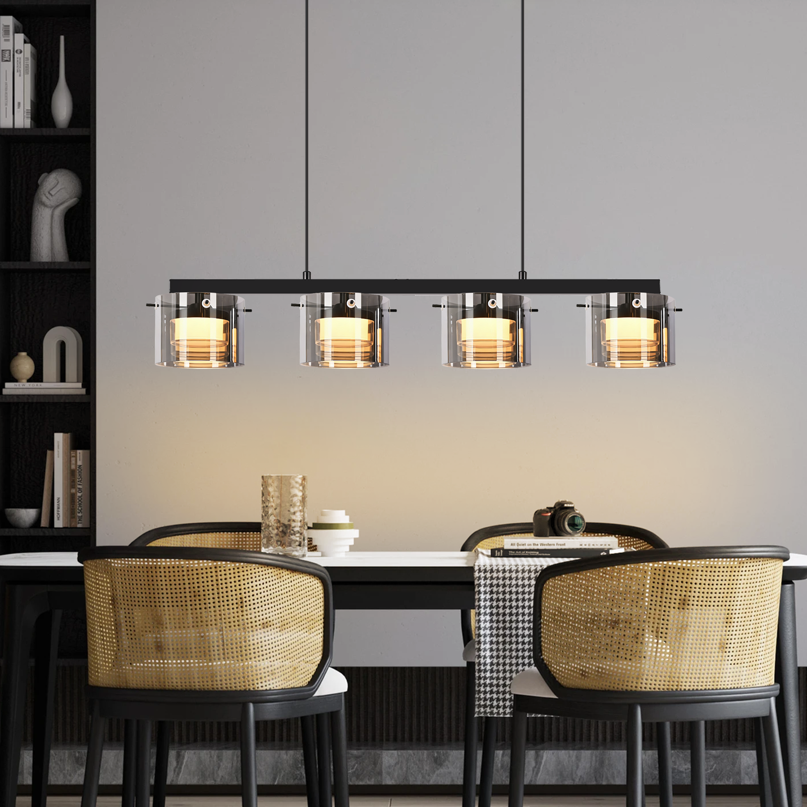 Ein moderner Essbereich mit einem schwarzen Tisch, vier Rattan-Stühlen und einer linearen Pendelleuchte.