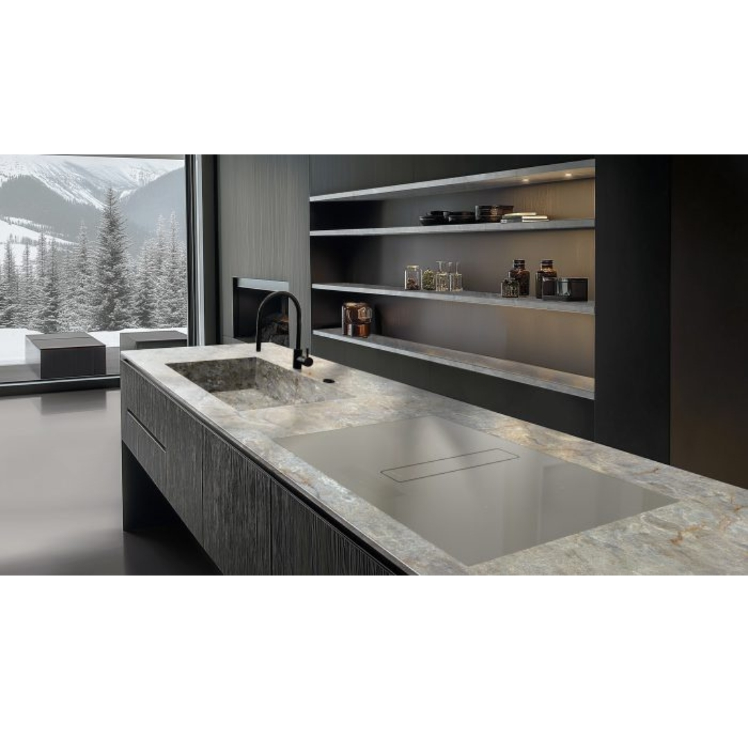 Cucina moderna con isola in marmo, lavello, piano cottura a induzione e vista invernale.