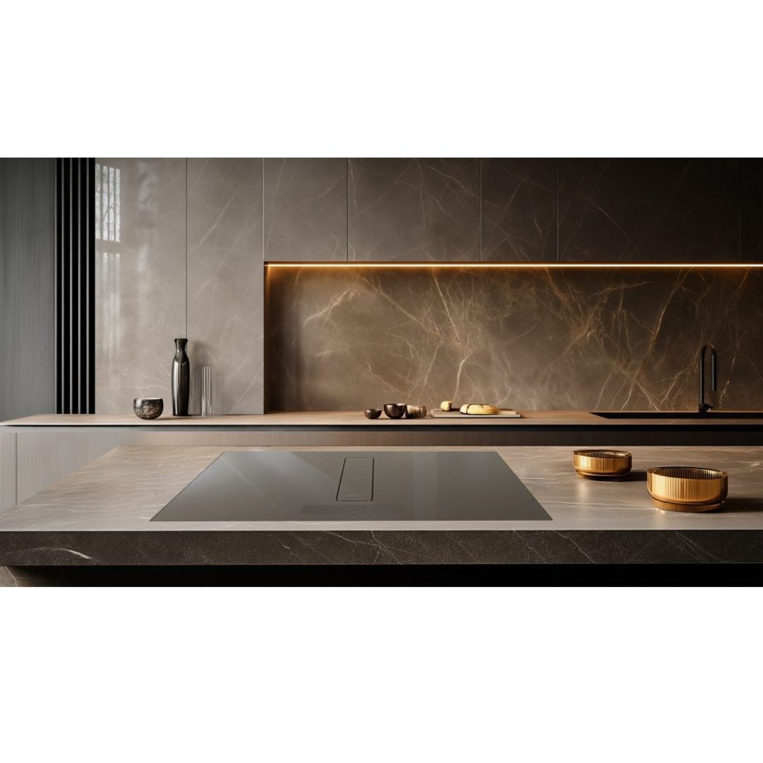 Cucina moderna con isola, superfici in marmo e piano cottura integrato.
