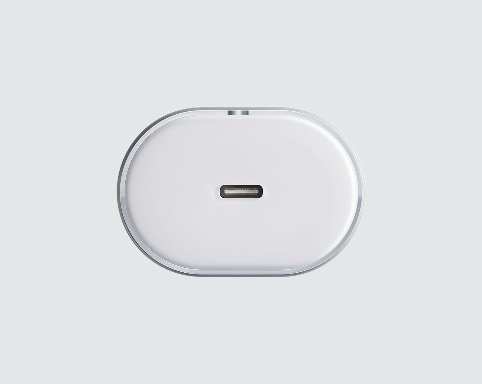 Gümüş kenarlı beyaz USB-C şarj cihazı gri arka planda.