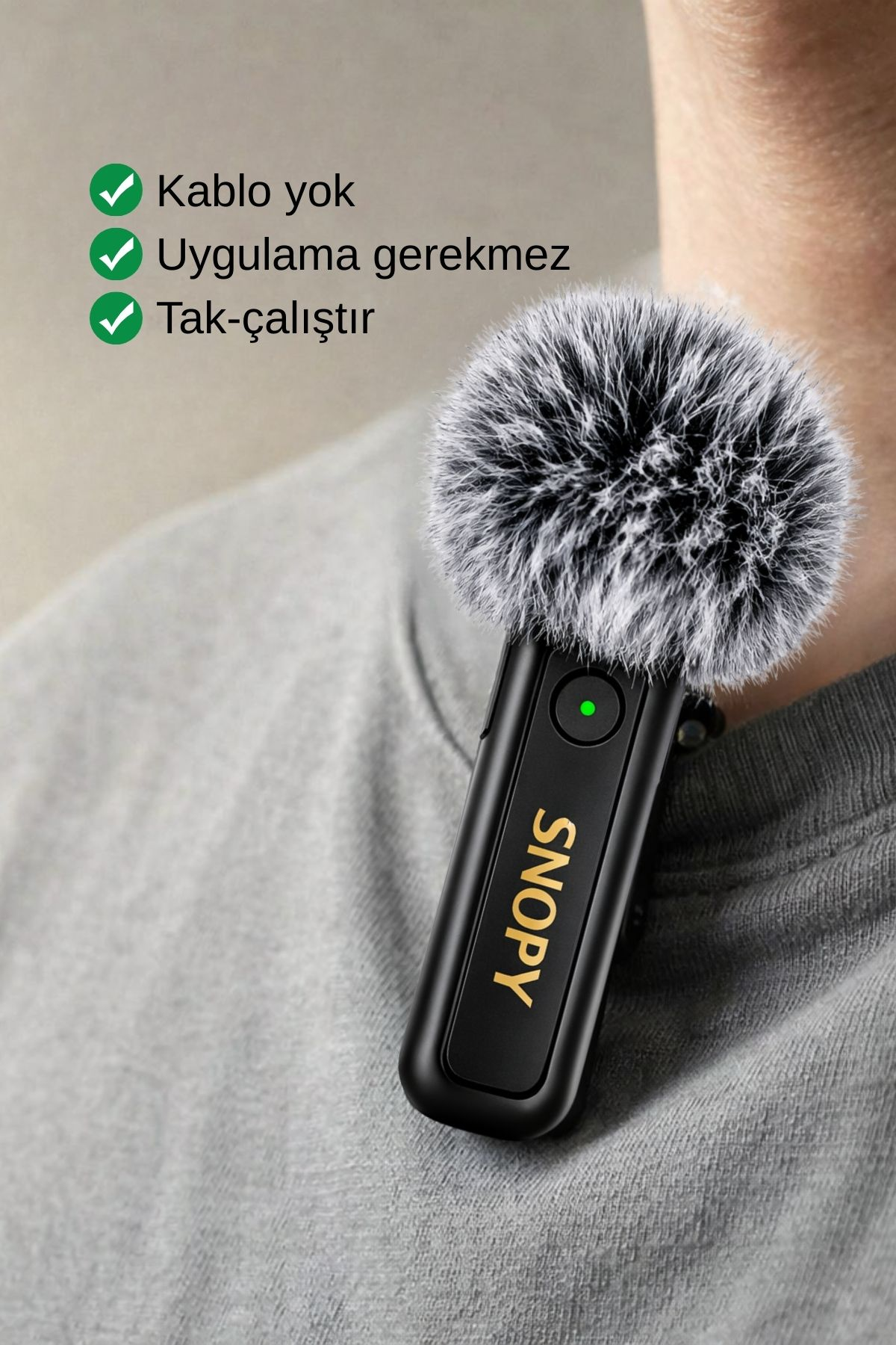 Gri kazağı olan bir erkeğin boynunda takılı kürklü siyah mikrofon.