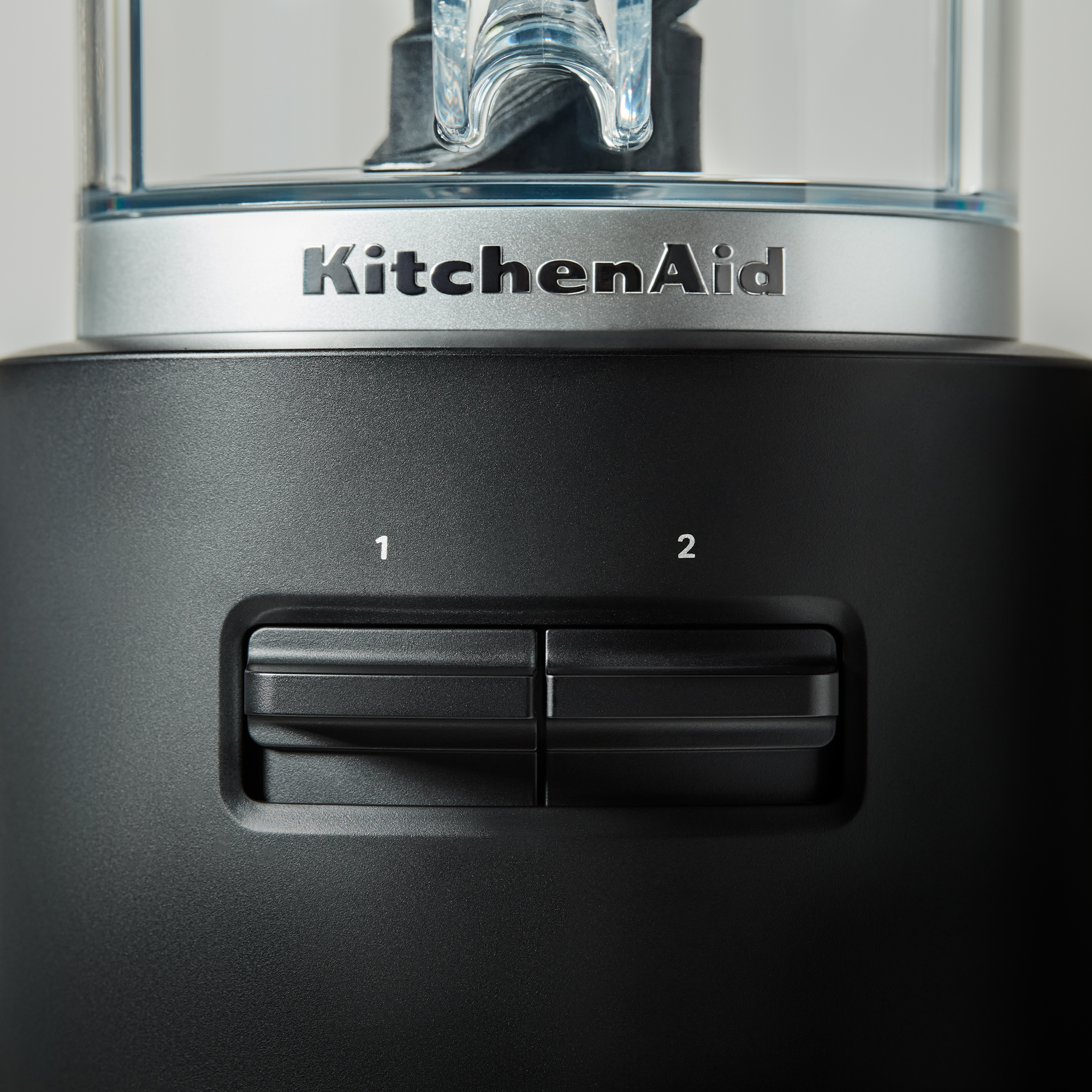 Primo piano di un frullatore KitchenAid nero con logo e controlli argentati.