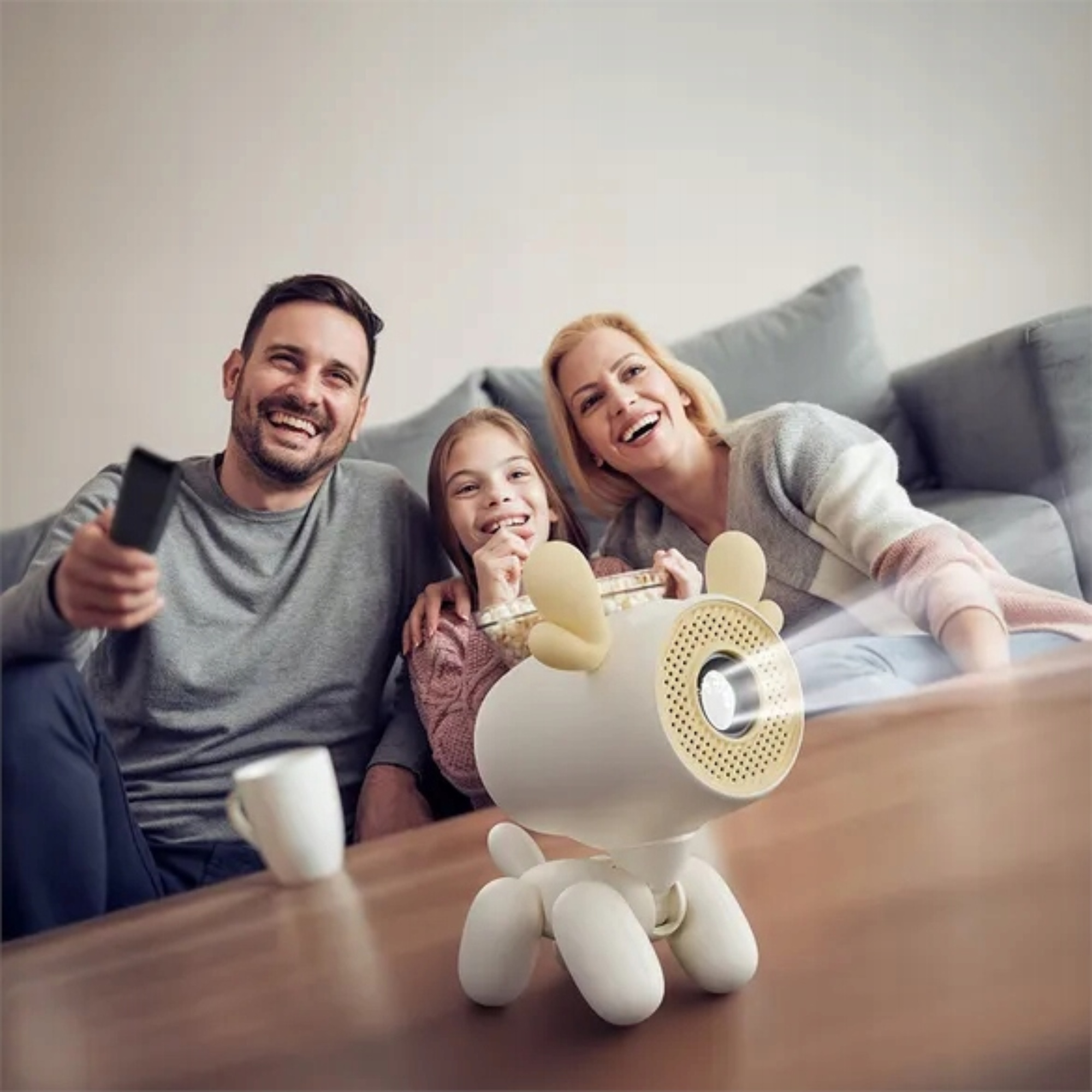Familie schaut einen Film mit einem Hund-Projektor und Popcorn.