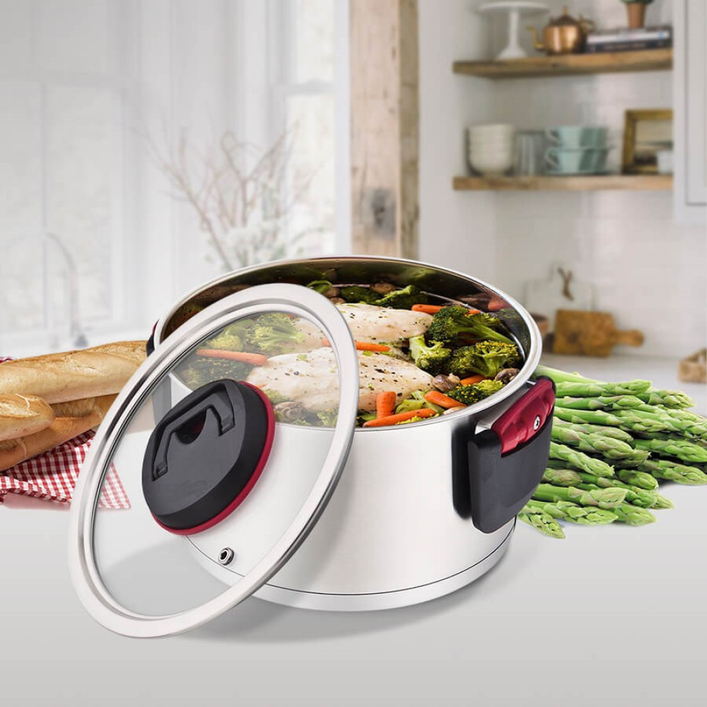 Garnek z rybą, brokułami, marchewką i szparagami obok.