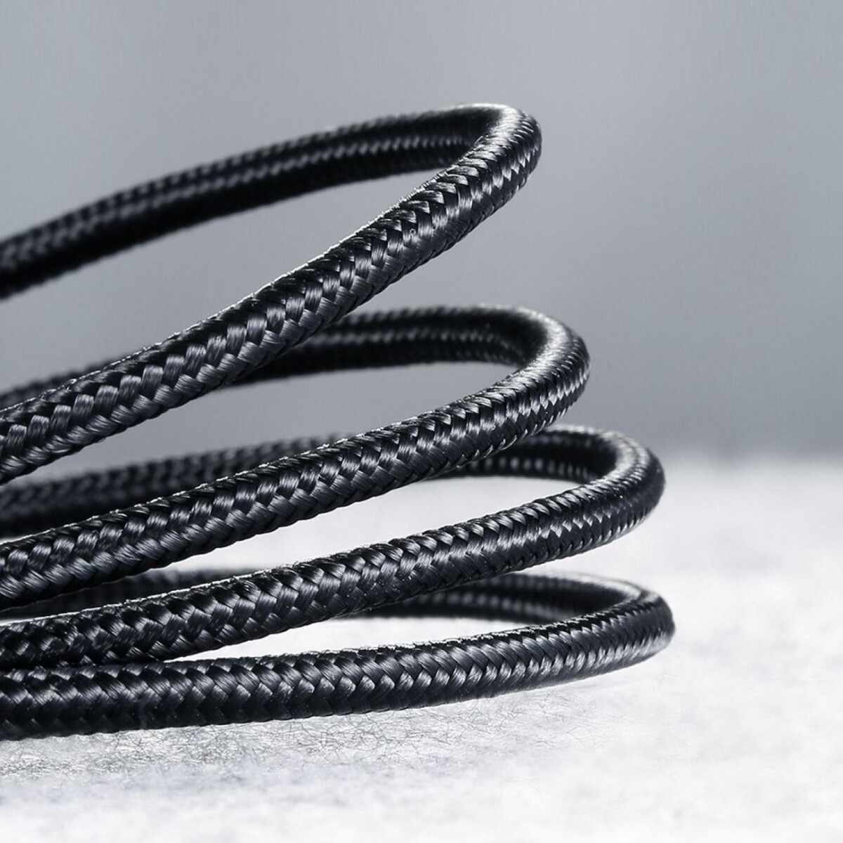 Czarny, pleciony kabel zwinięty w ciasne spirale.