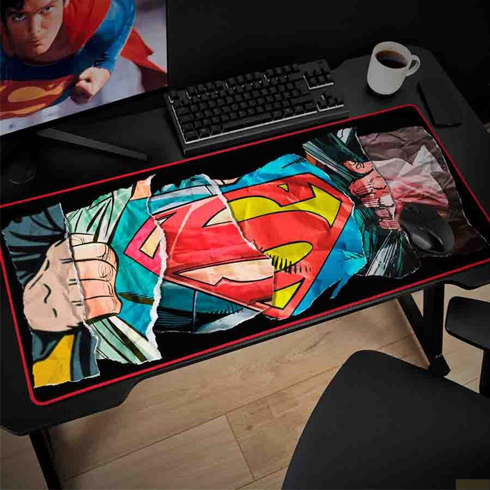 Superman-Logo auf zerrissenem Comic-Print auf einem Schreibtisch mit Tastatur, Maus und Kaffee.