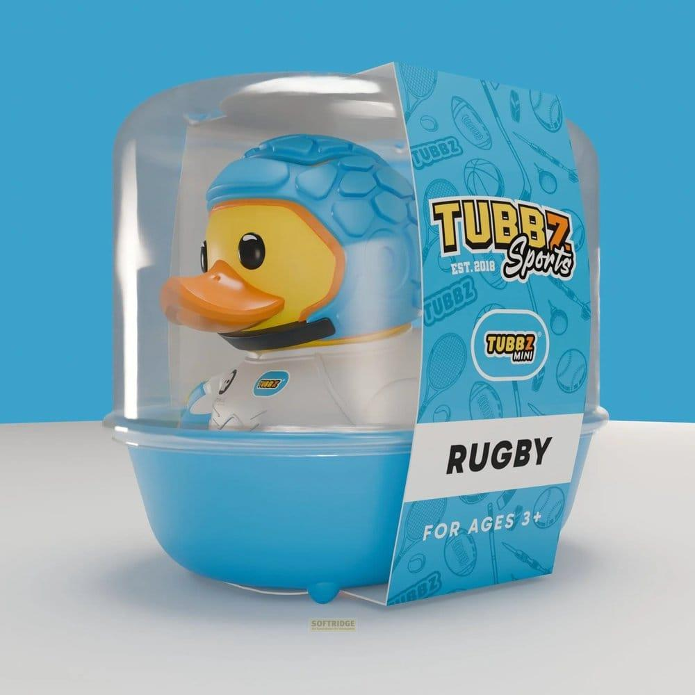 Ein gelbe Badeente mit blauem Rugbyhelm und weißem Anzug in einer blauen Verpackung.