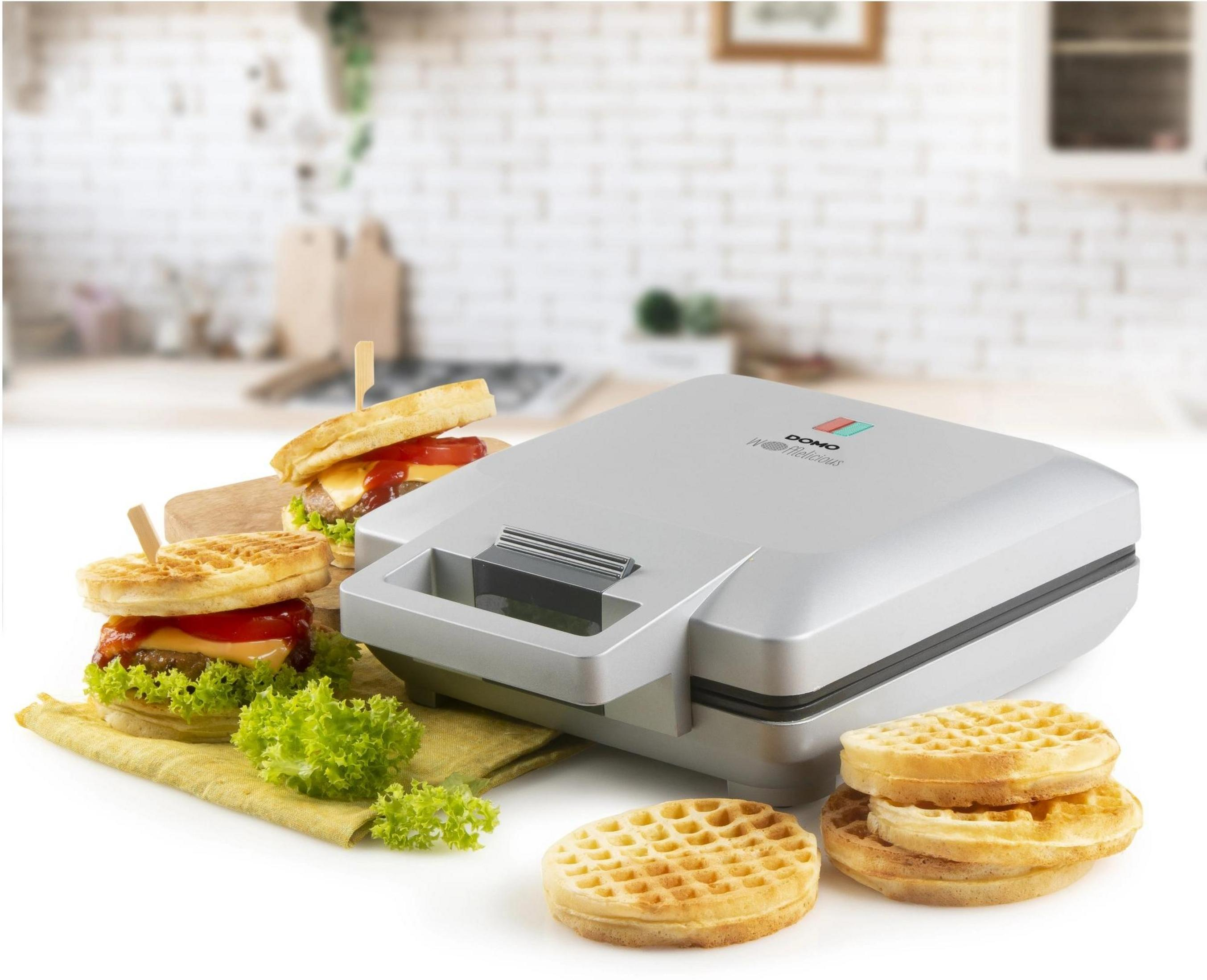 Silberner Waffelmaker mit Waffeln und Mini-Burgern daneben.