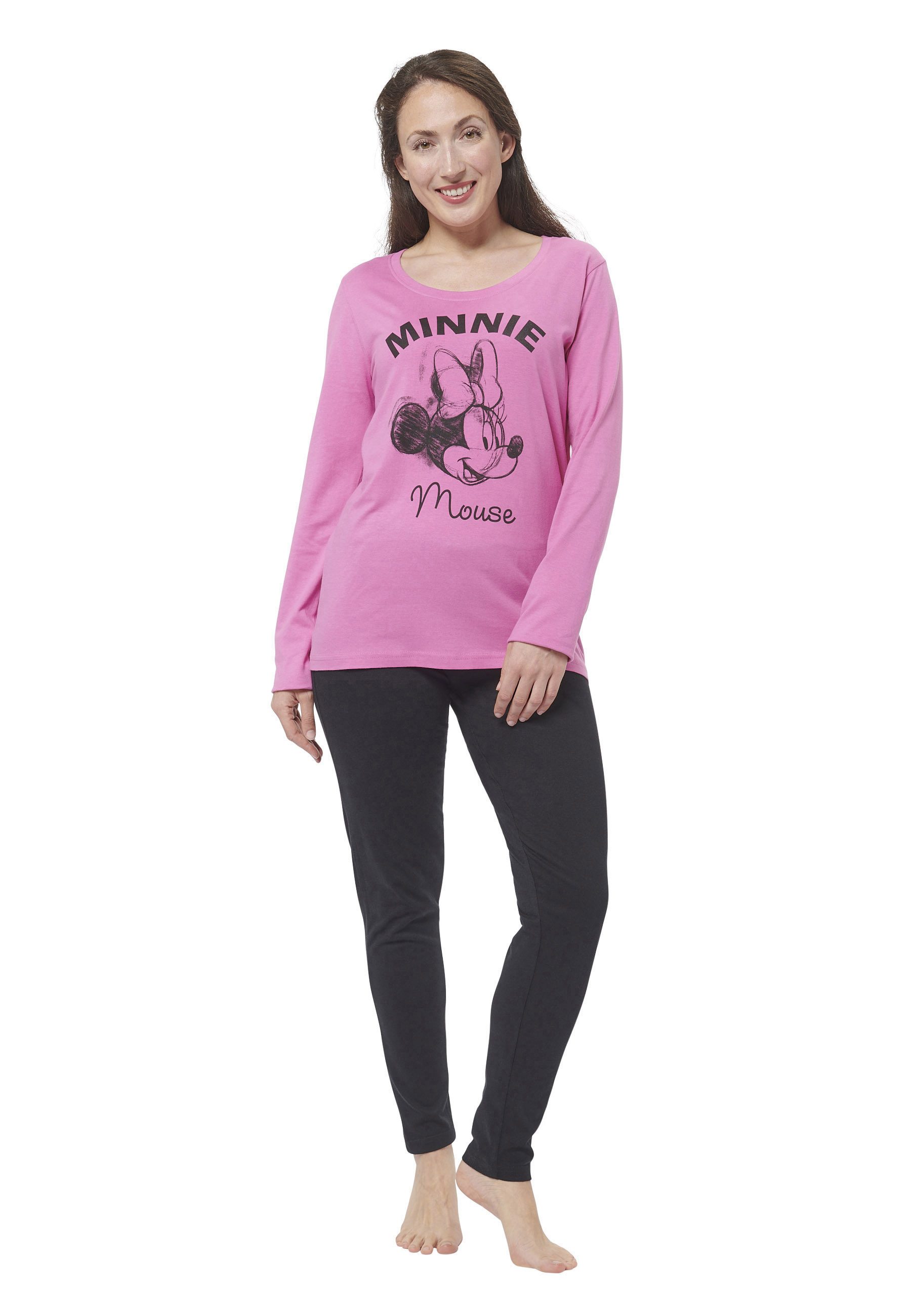 Eine Frau in einem rosafarbenen Oberteil mit Minnie Maus und schwarzen Hosen.